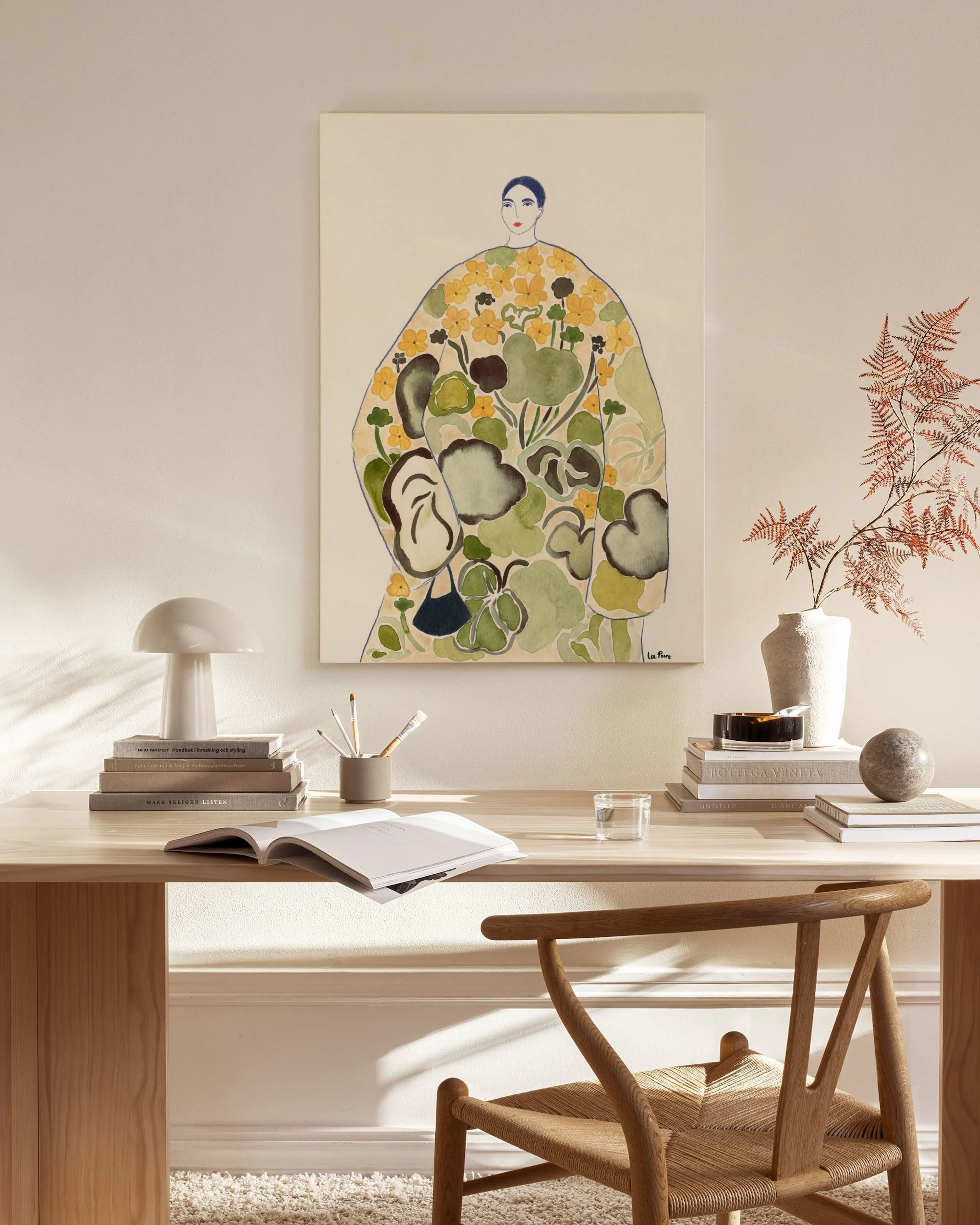 Leinwandbild einer Person in einem blumigen Gewand mit gelben Blüten und grünen Blättern, über einem Sideboard im Wohnzimmer.