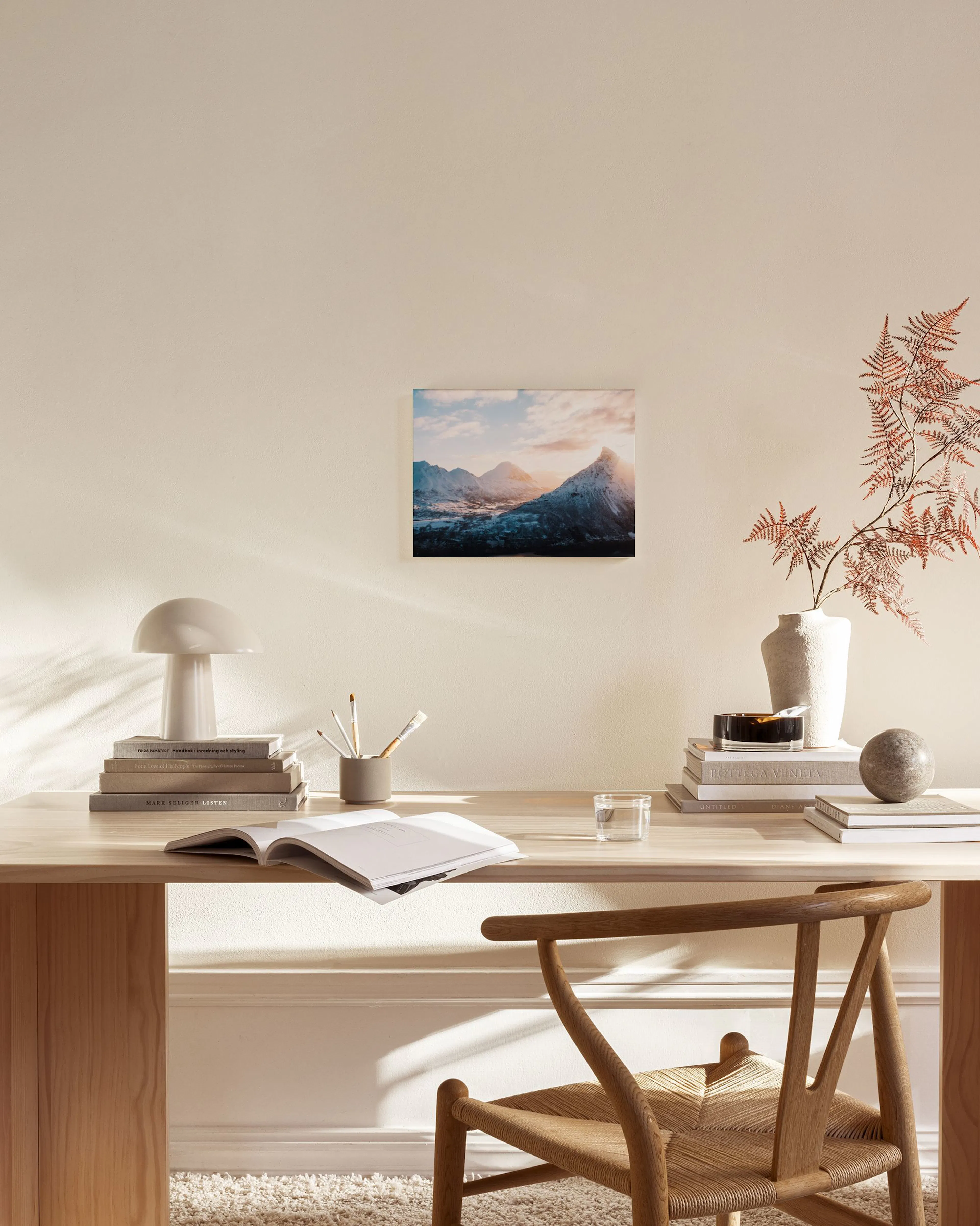 Leinwandbild mit schneebedeckten Bergen bei Sonnenuntergang in einem modernen Wohnzimmer über einem Sideboard.