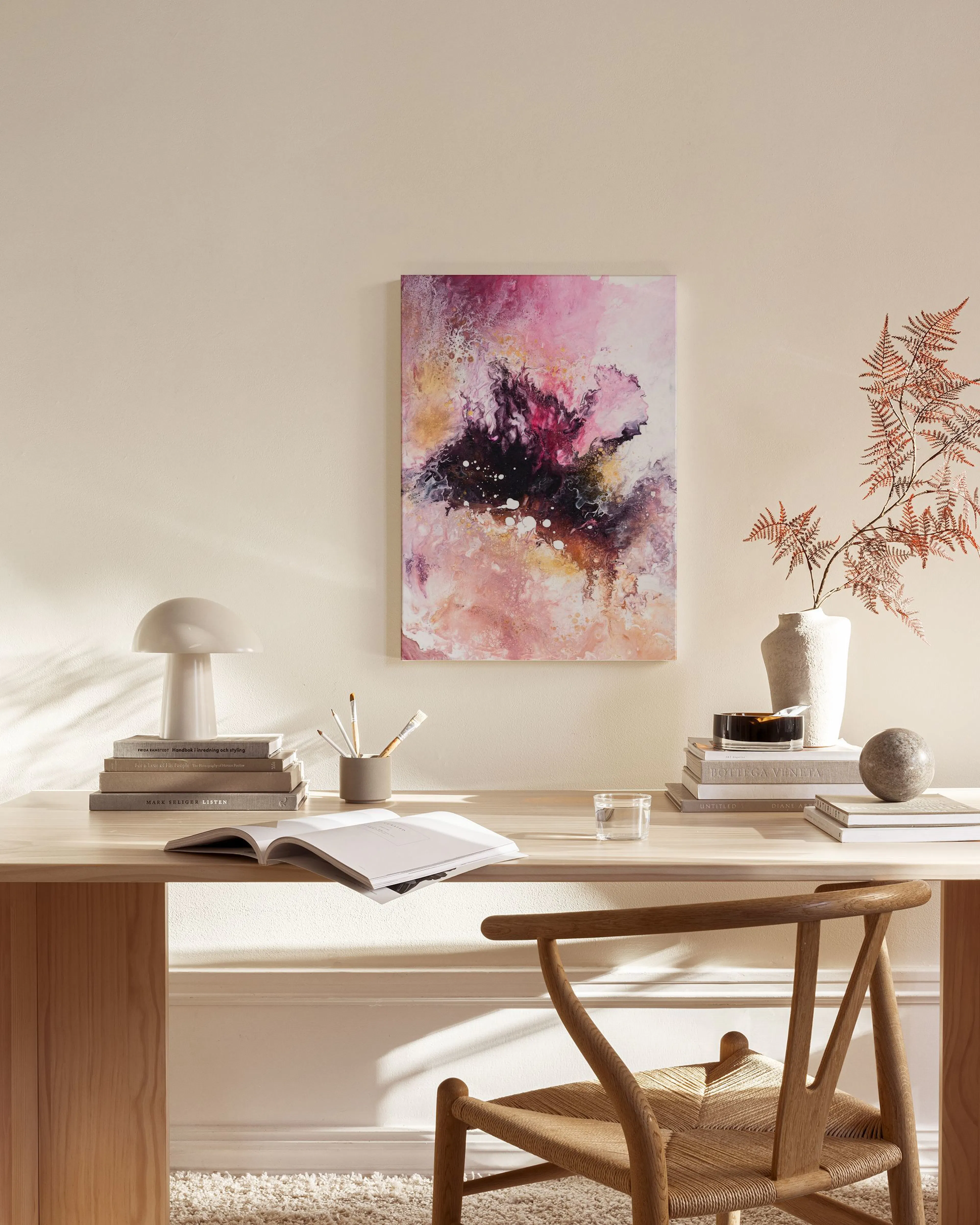 Abstract canvas print with pink, purple, and white swirls, displayed in a bright living room above a wooden console.