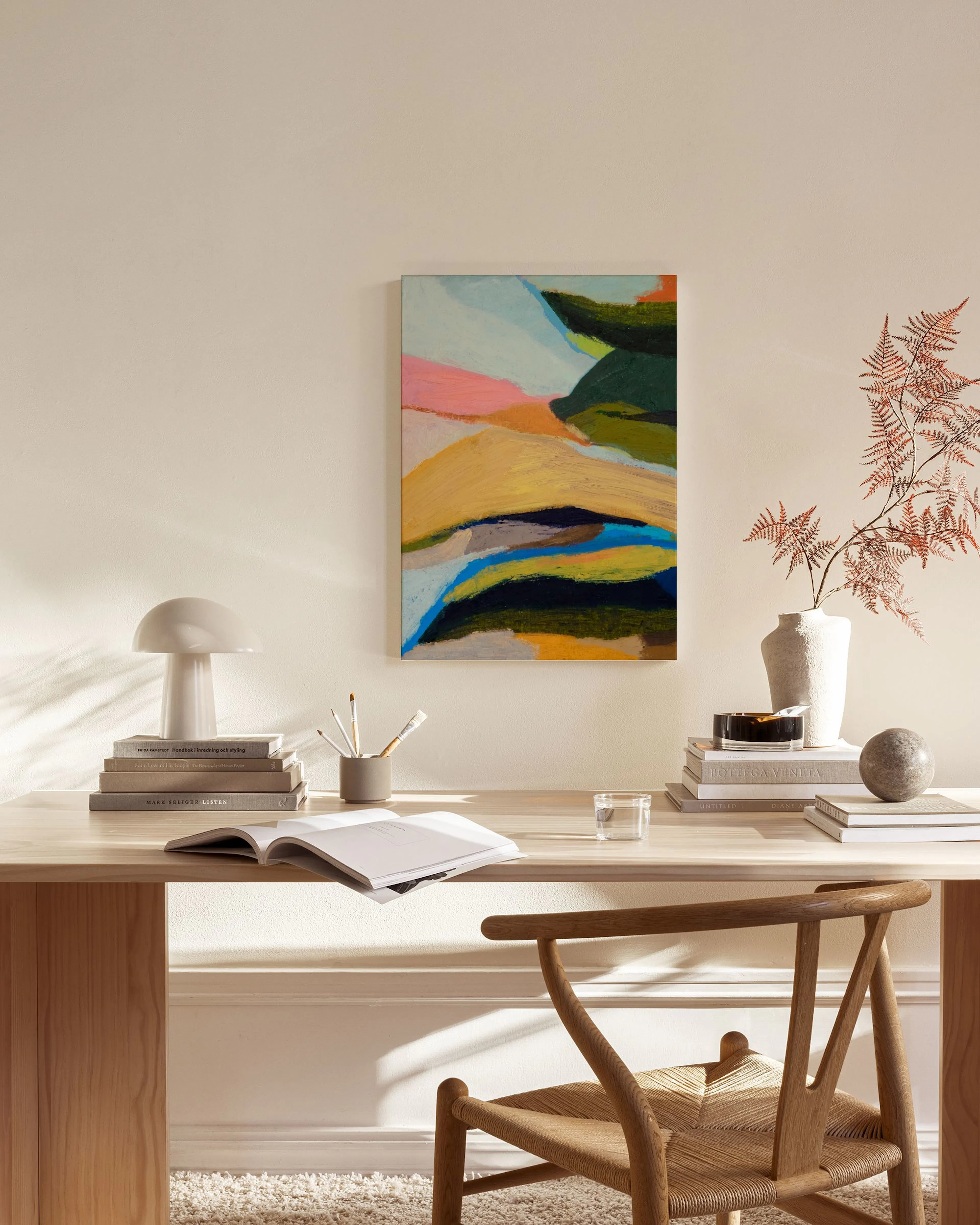 Abstraktes Leinwandbild mit bunten, organischen Formen in Grün, Gelb, Pink und Blau, aufgehängt in einem hellen Wohnzimmer über 