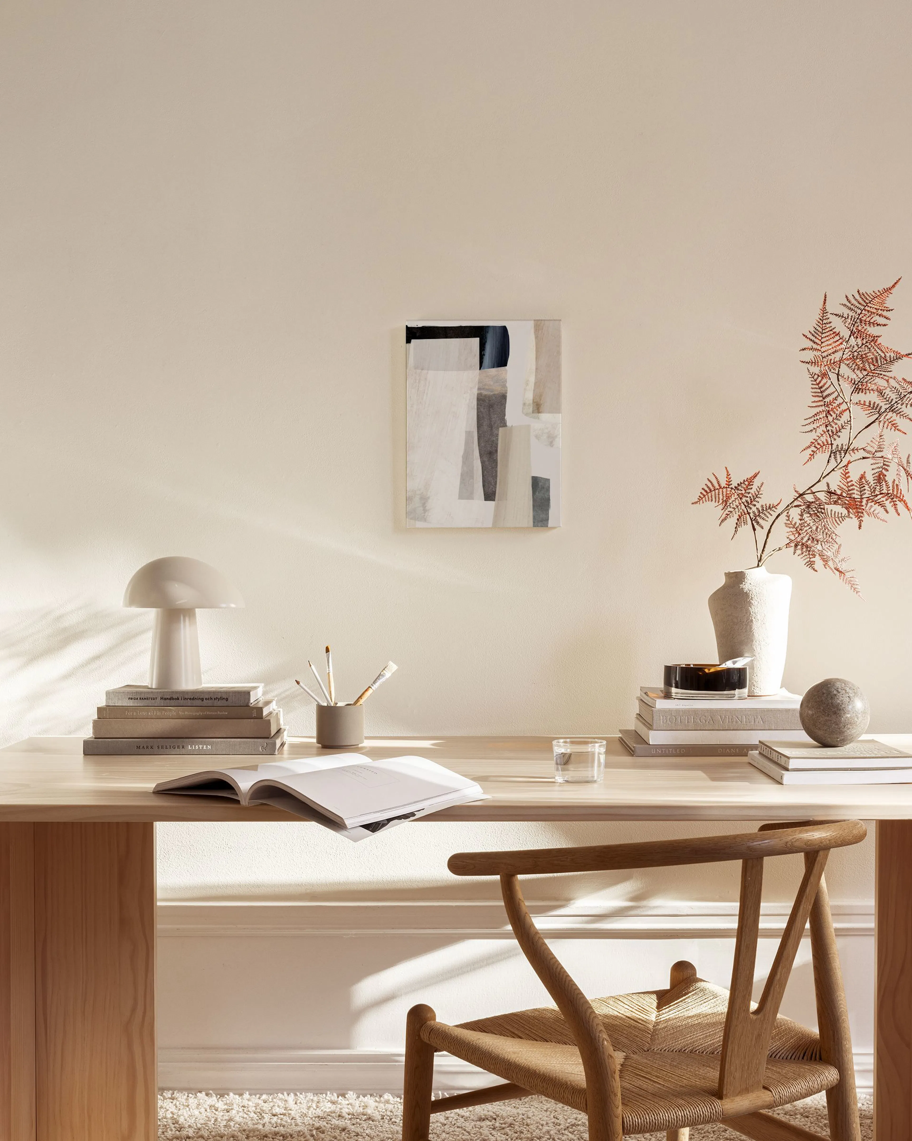 Leinwandbild mit abstrakten Formen in Beige, Grau und Schwarz, über einem Sideboard in einem modernen Wohnzimmer.