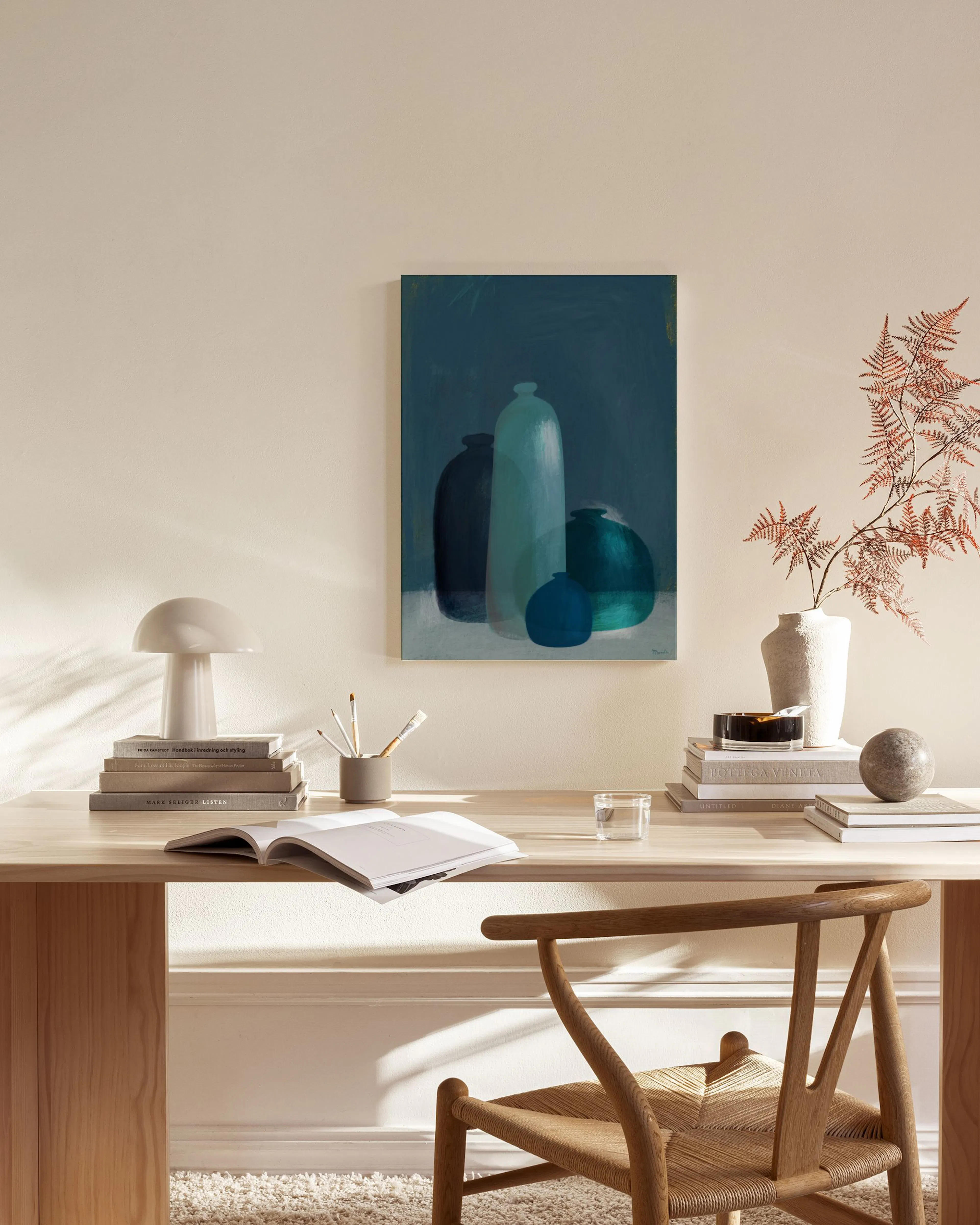 A canvas print showcasing blue and teal vases in various shapes, hanging above a wooden console table in a minimalist living roo