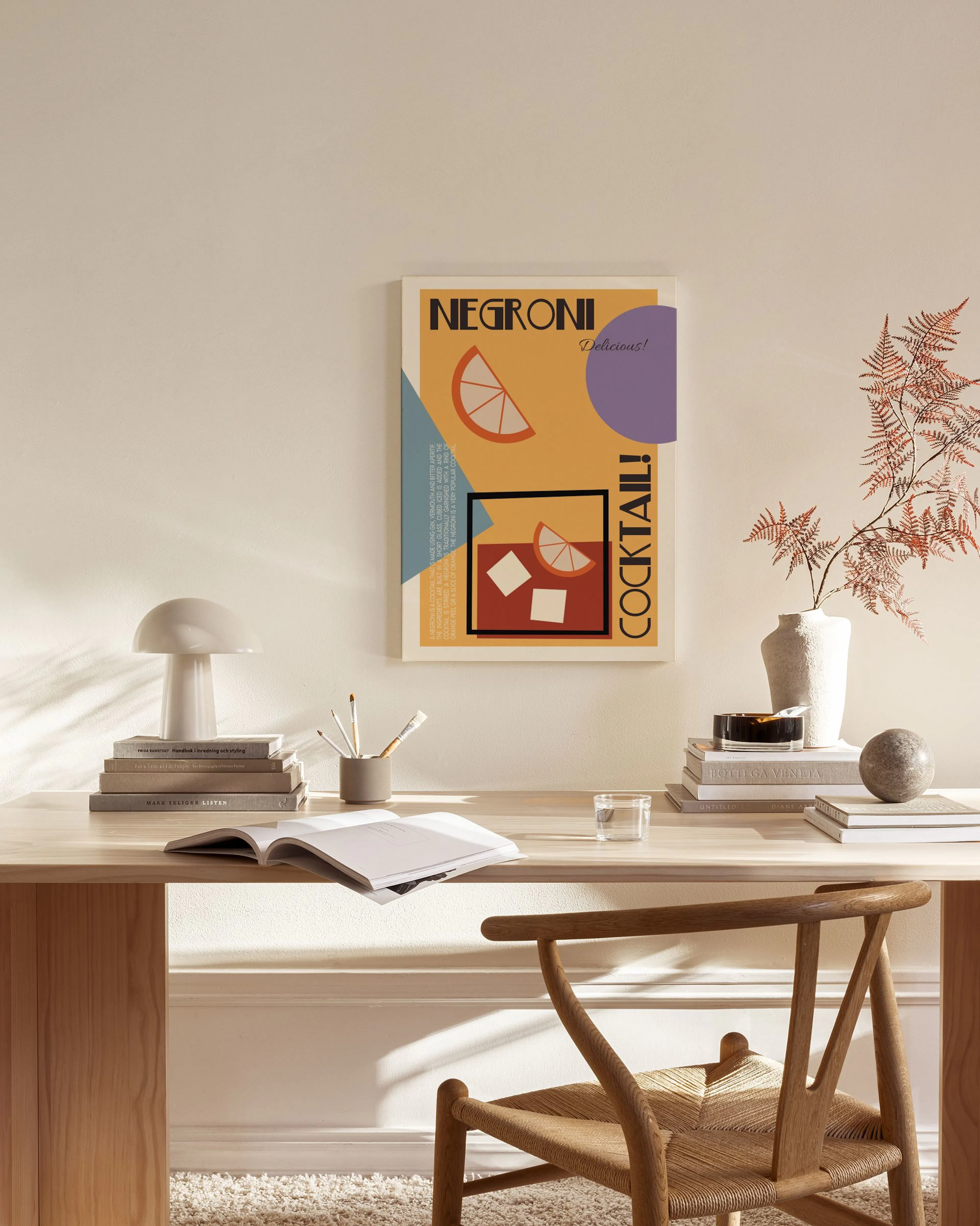A vintage Negroni cocktail canvas print with orange and purple accents, hanging above a wooden console table in a modern living 