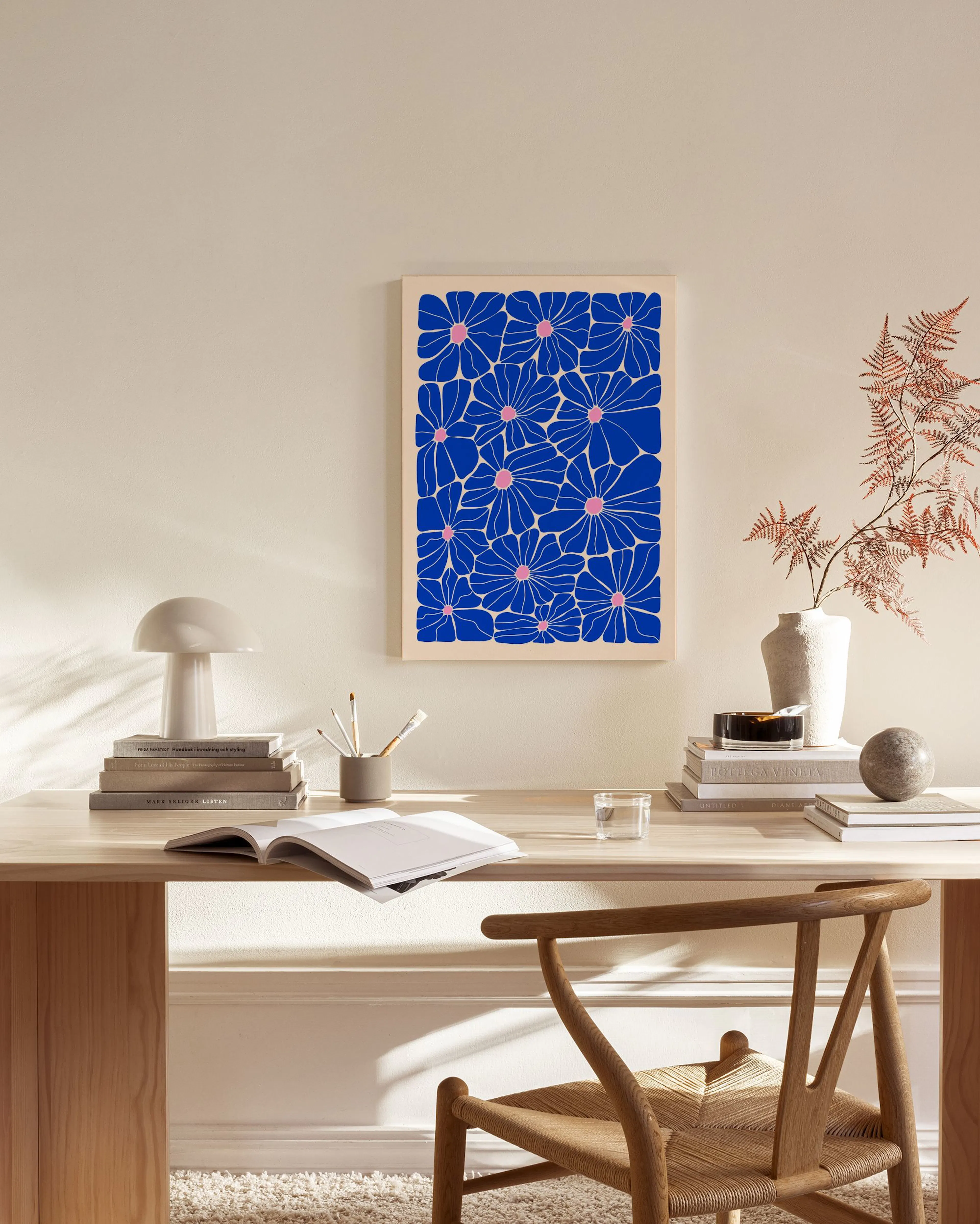 A blue and pink floral print hanging in a modern living room above a wooden console table.