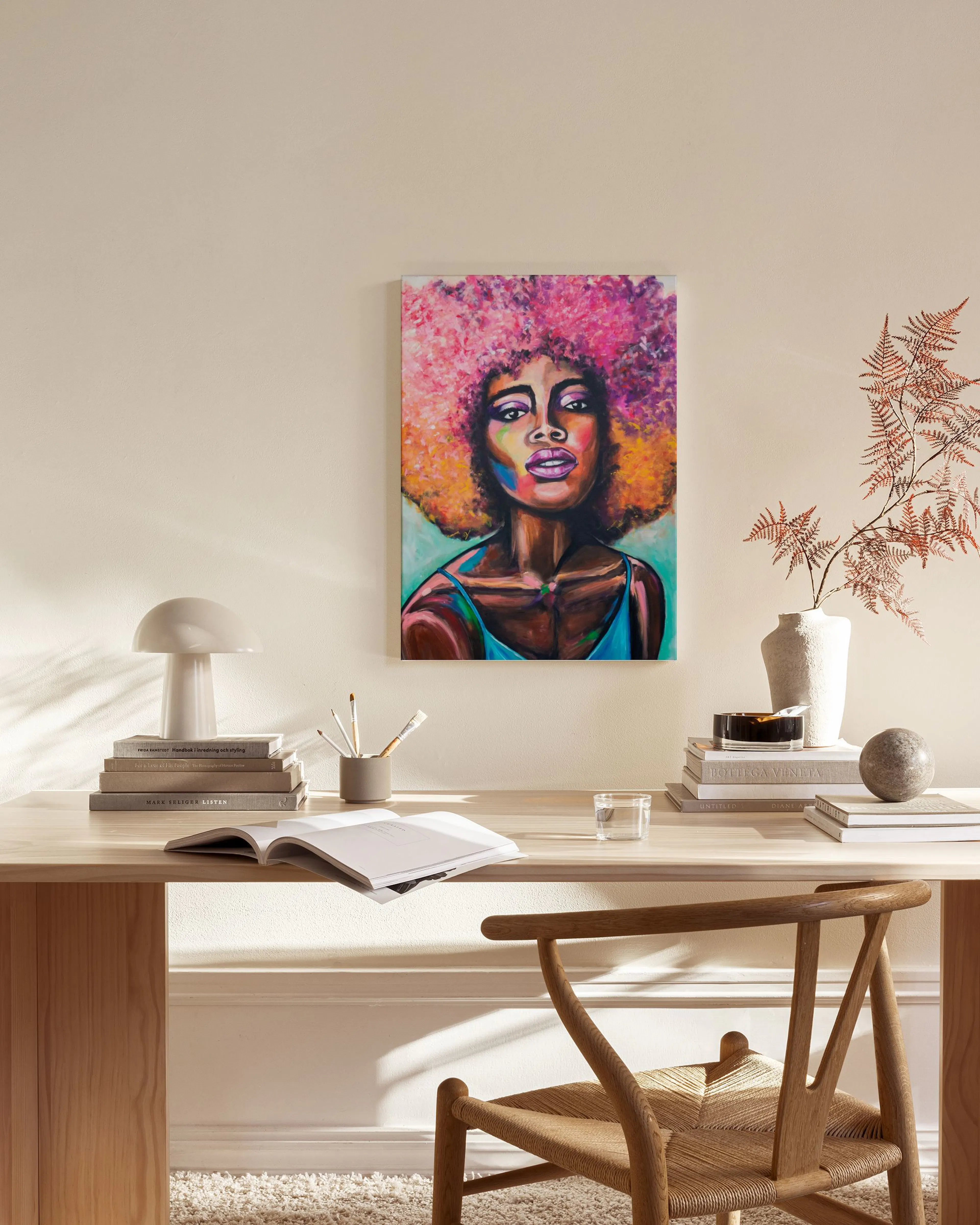 Vibrant canvas print of a Black woman with pink and orange afro, hanging in a minimalist living room above a wooden console tabl