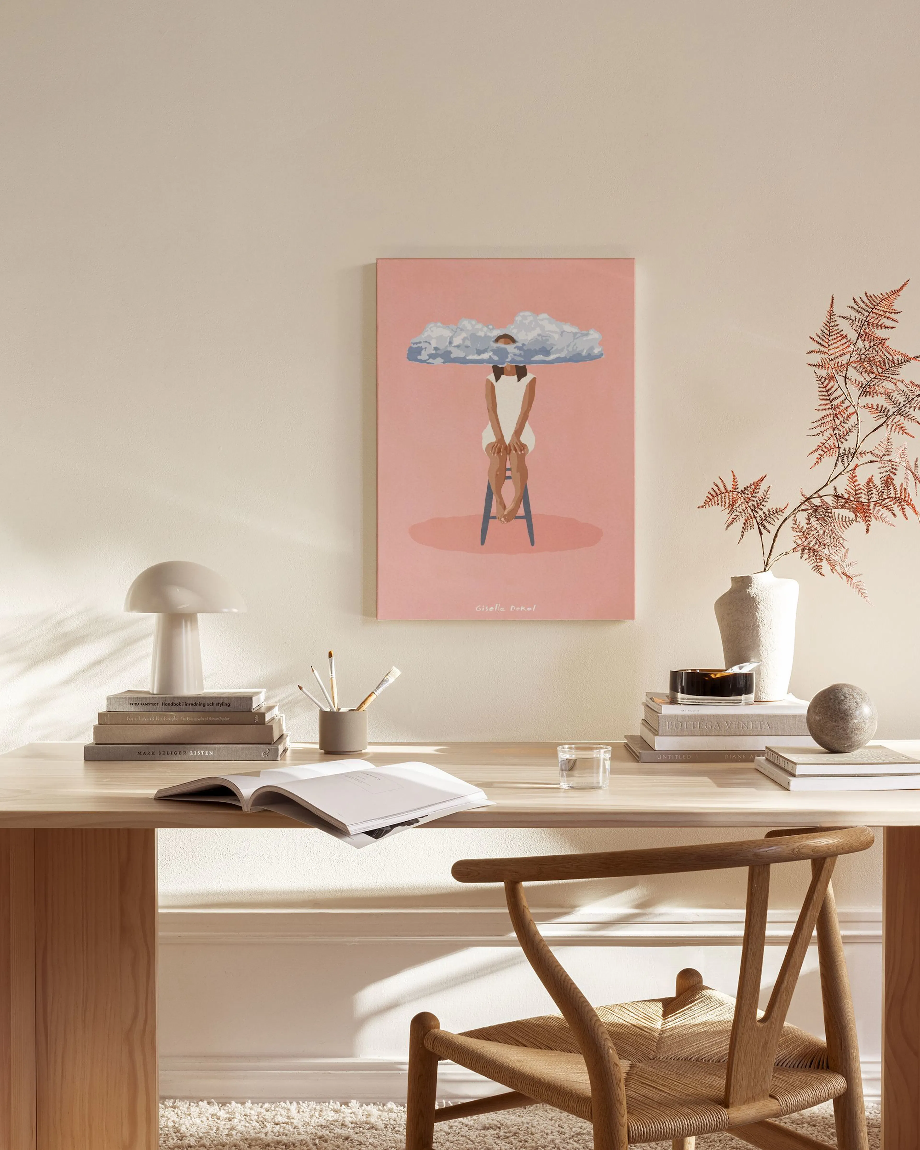 A canvas print of a person with a cloud over their head, sitting on a stool, displayed in a minimal living room.