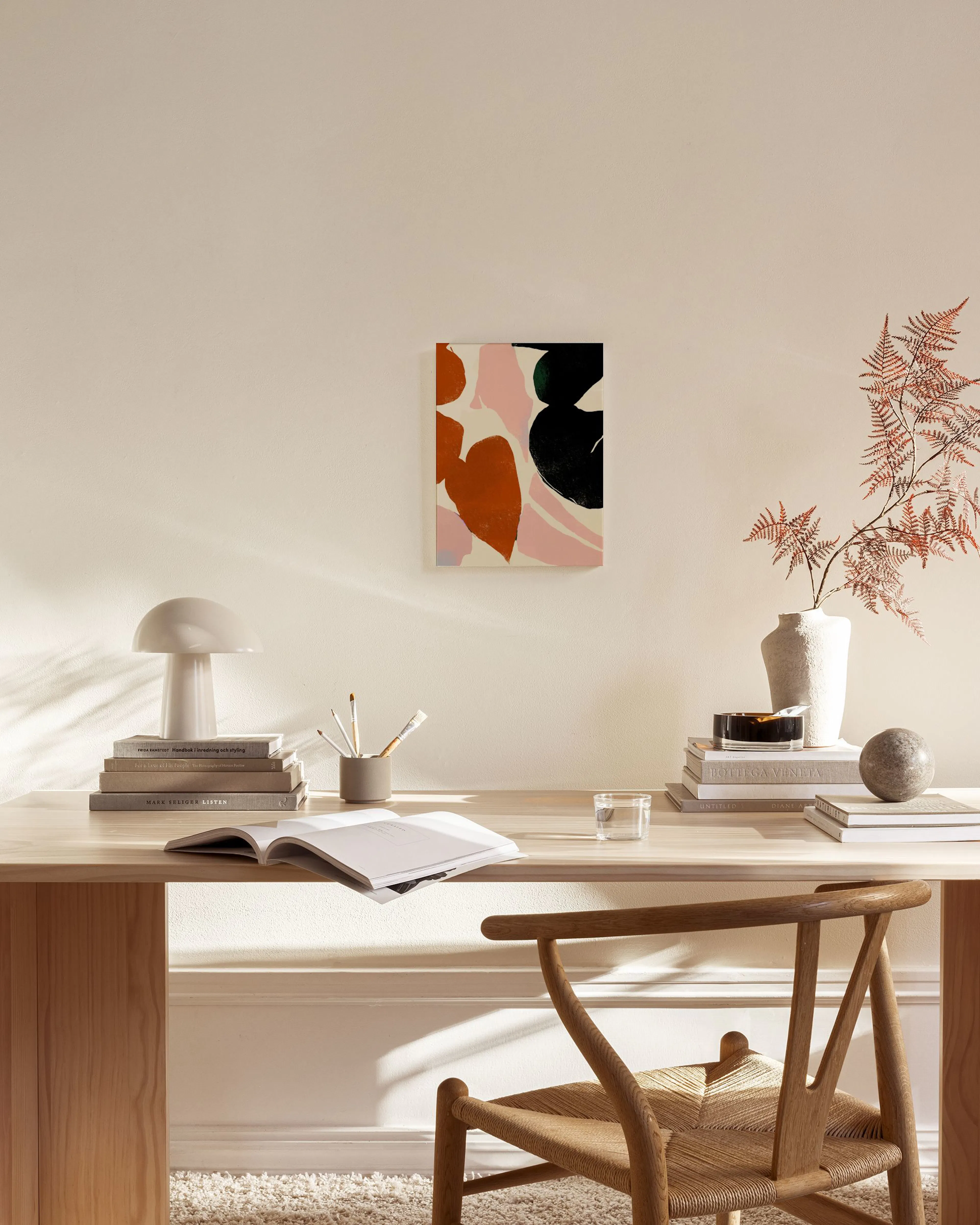 Toile abstraite aux formes organiques rouges, roses et noires, accrochée dans un salon moderne.