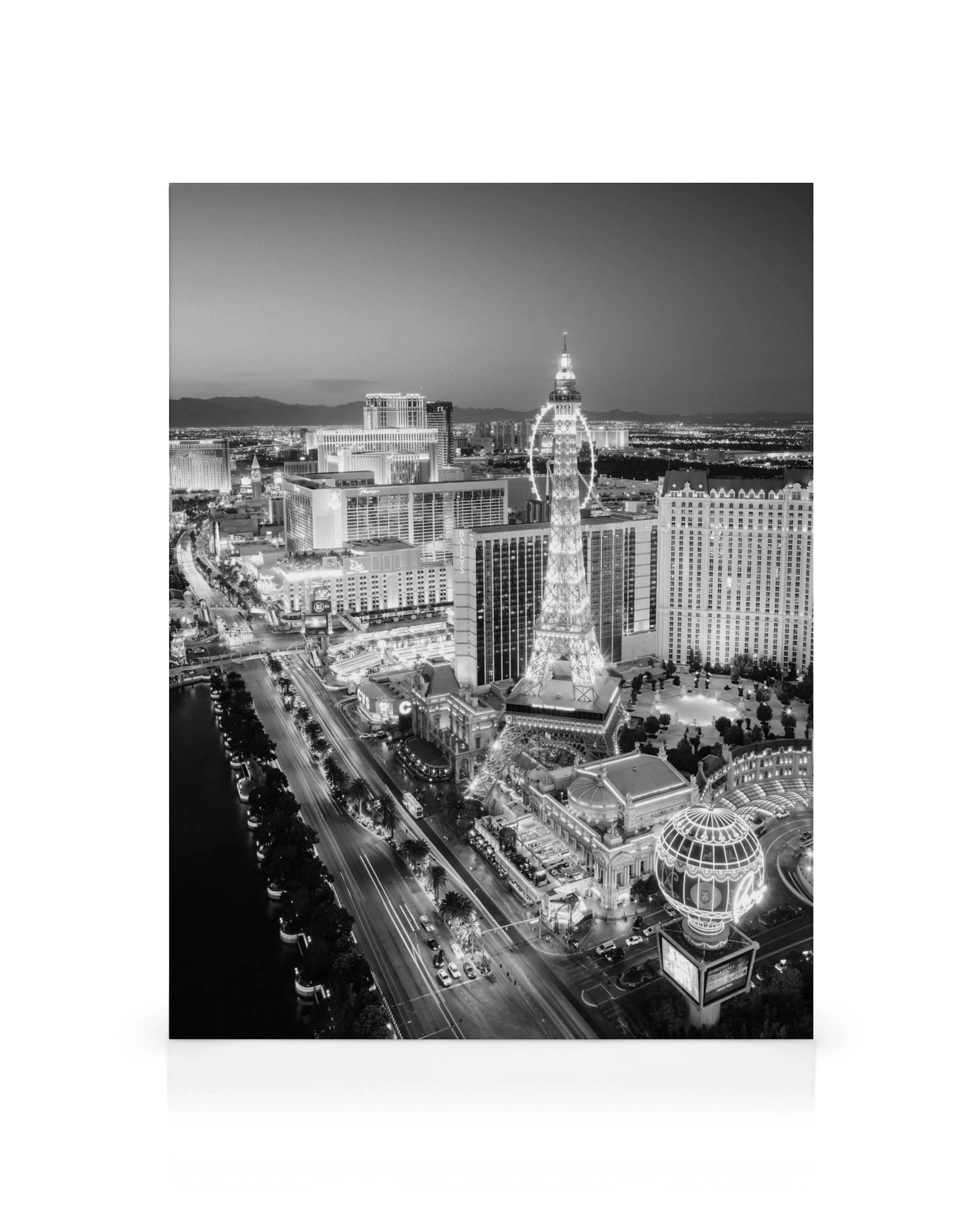 Black and white Las Vegas cityscape at dusk with illuminated skyscrapers, river, and streets, for a canvas print.