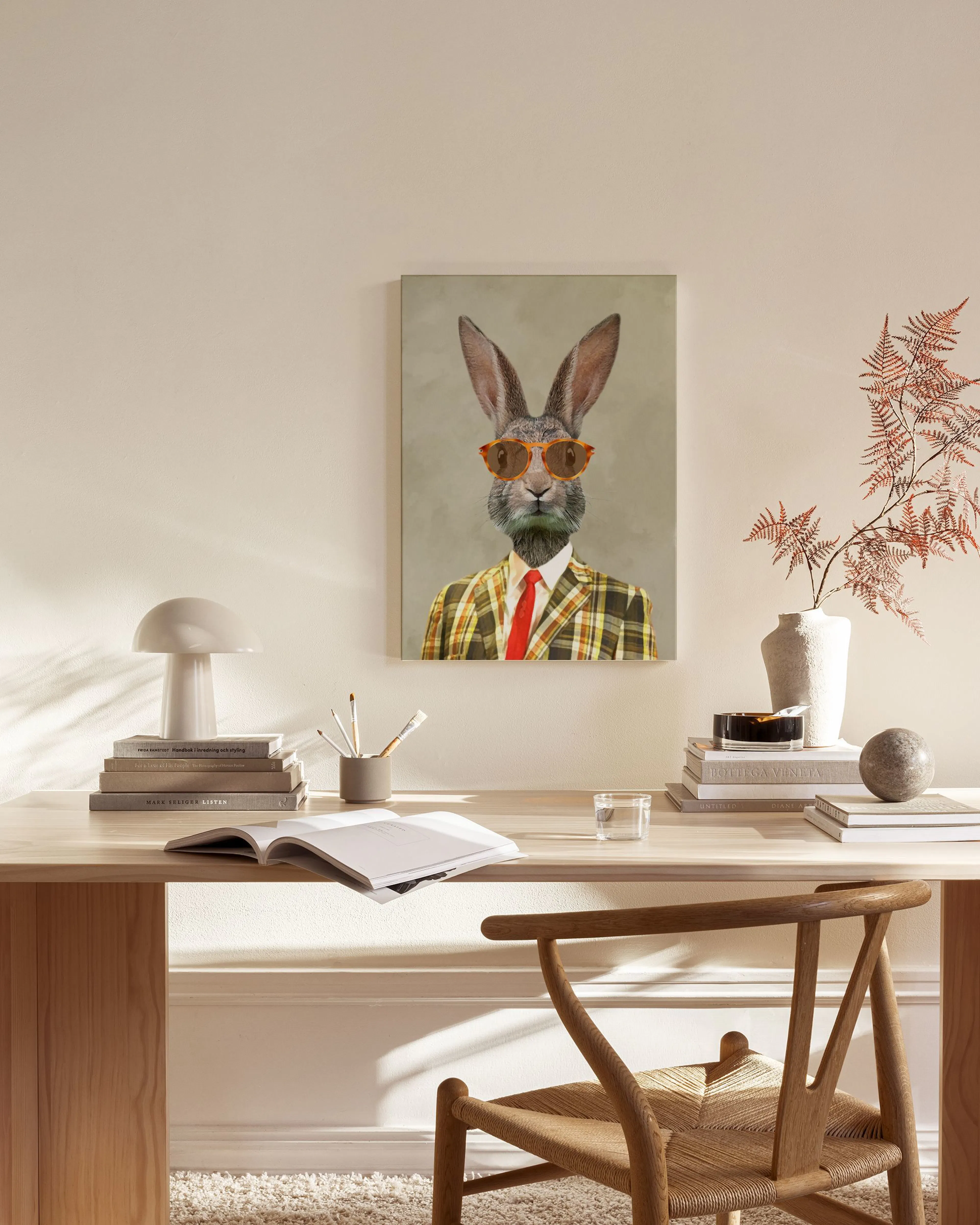 Lienzo de un conejo con gafas de sol y traje a cuadros, colgado en una sala de estar moderna con muebles de madera.