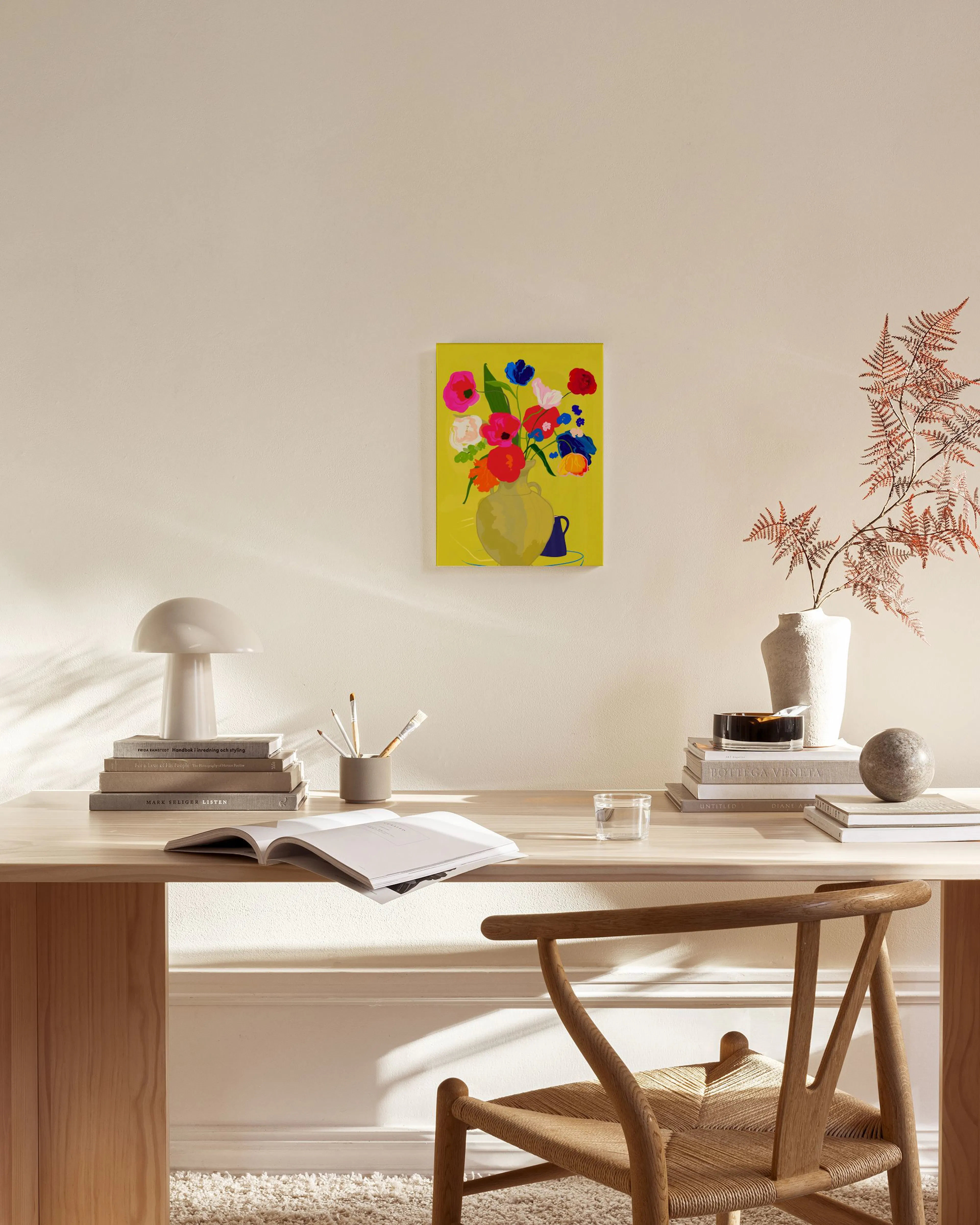 Leinwandbild mit farbenfrohem Blumenstrauß in Vase auf gelbem Hintergrund, hängend im Wohnzimmer über einem Sideboard.