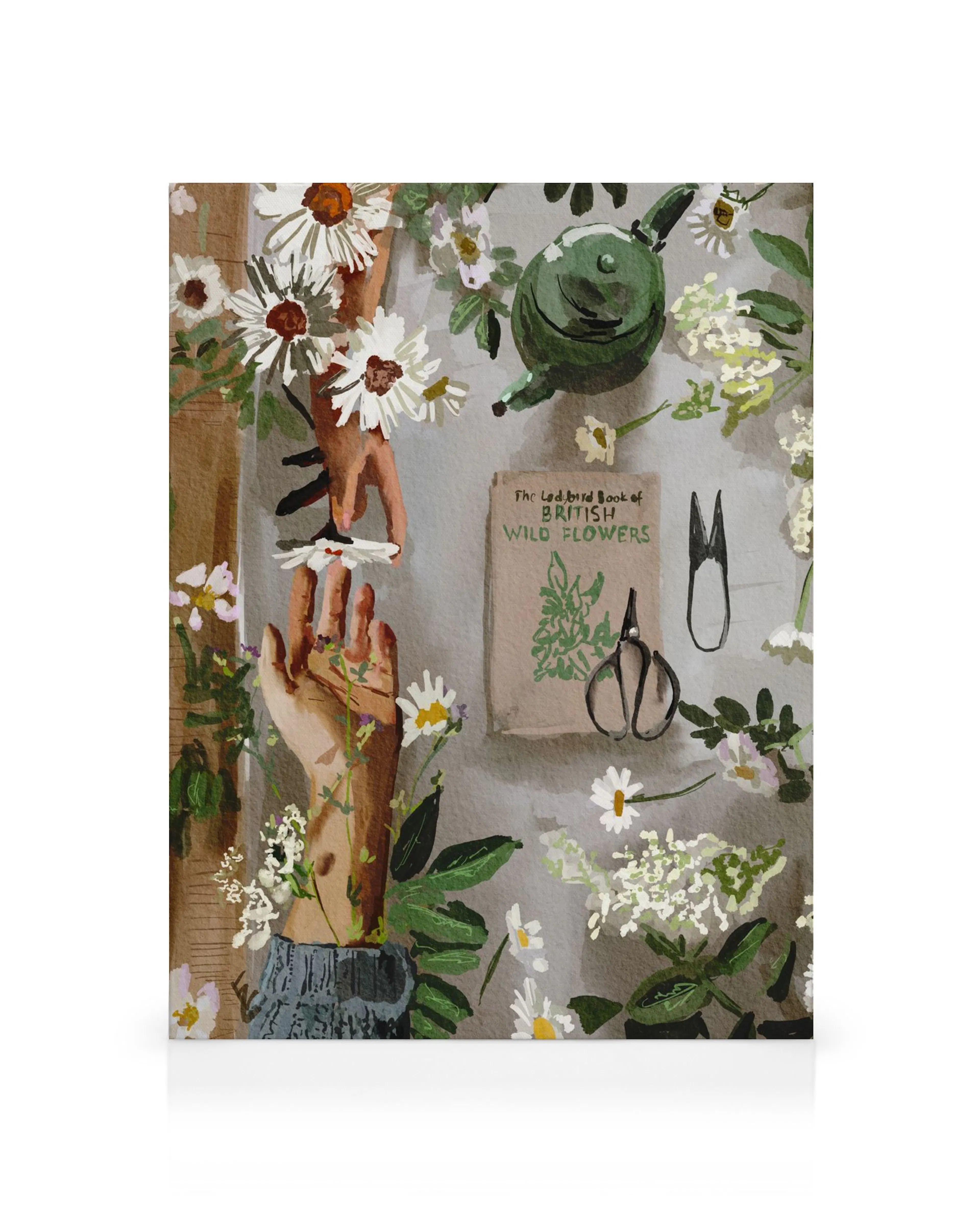 Stampa su tela con due mani che raccolgono margherite, un libro di fiori selvatici, forbici e una teiera verde su sfondo grigio.