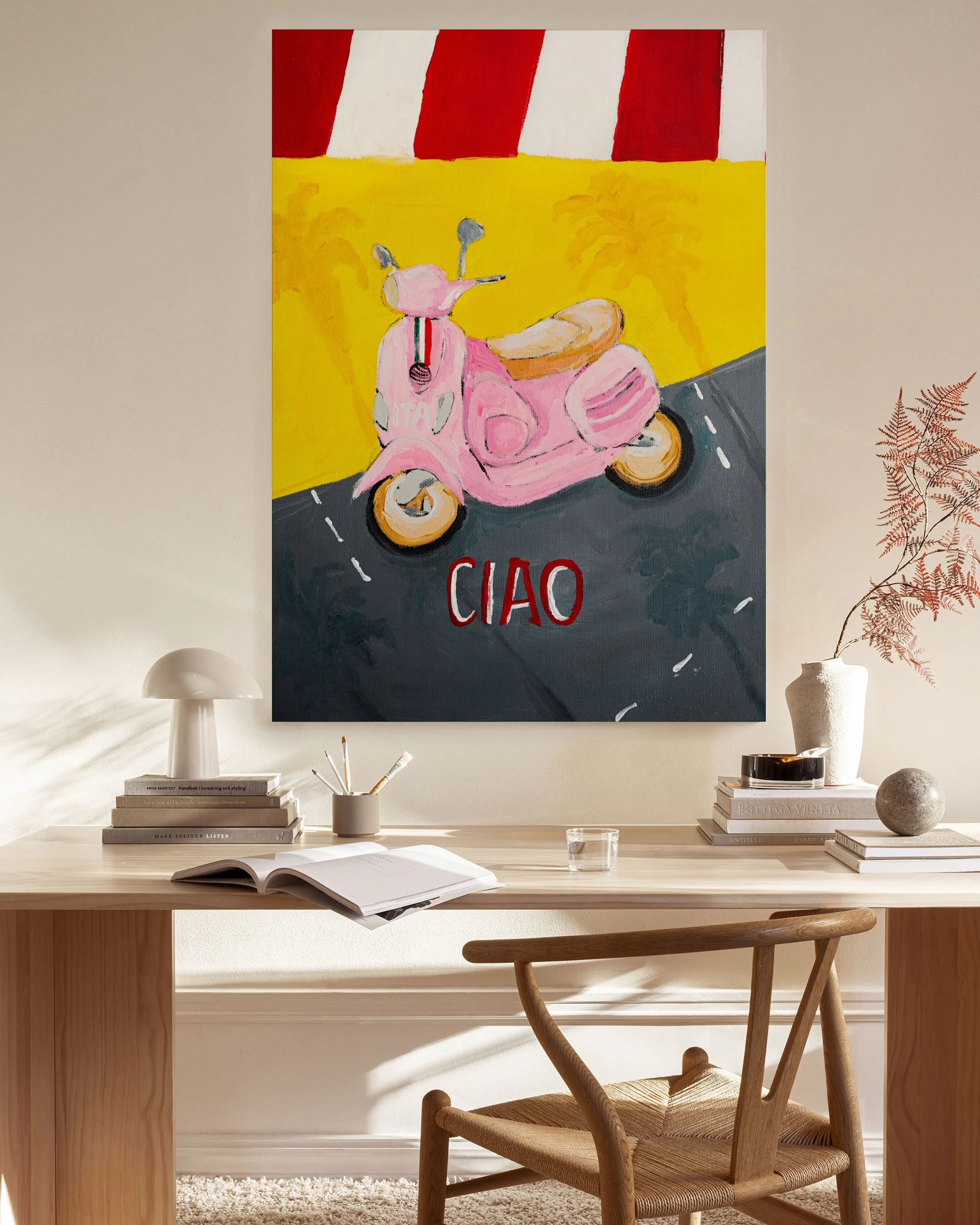 Stampa su tela con Vespa rosa e scritta CIAO, appesa in un soggiorno moderno sopra una credenza in legno.