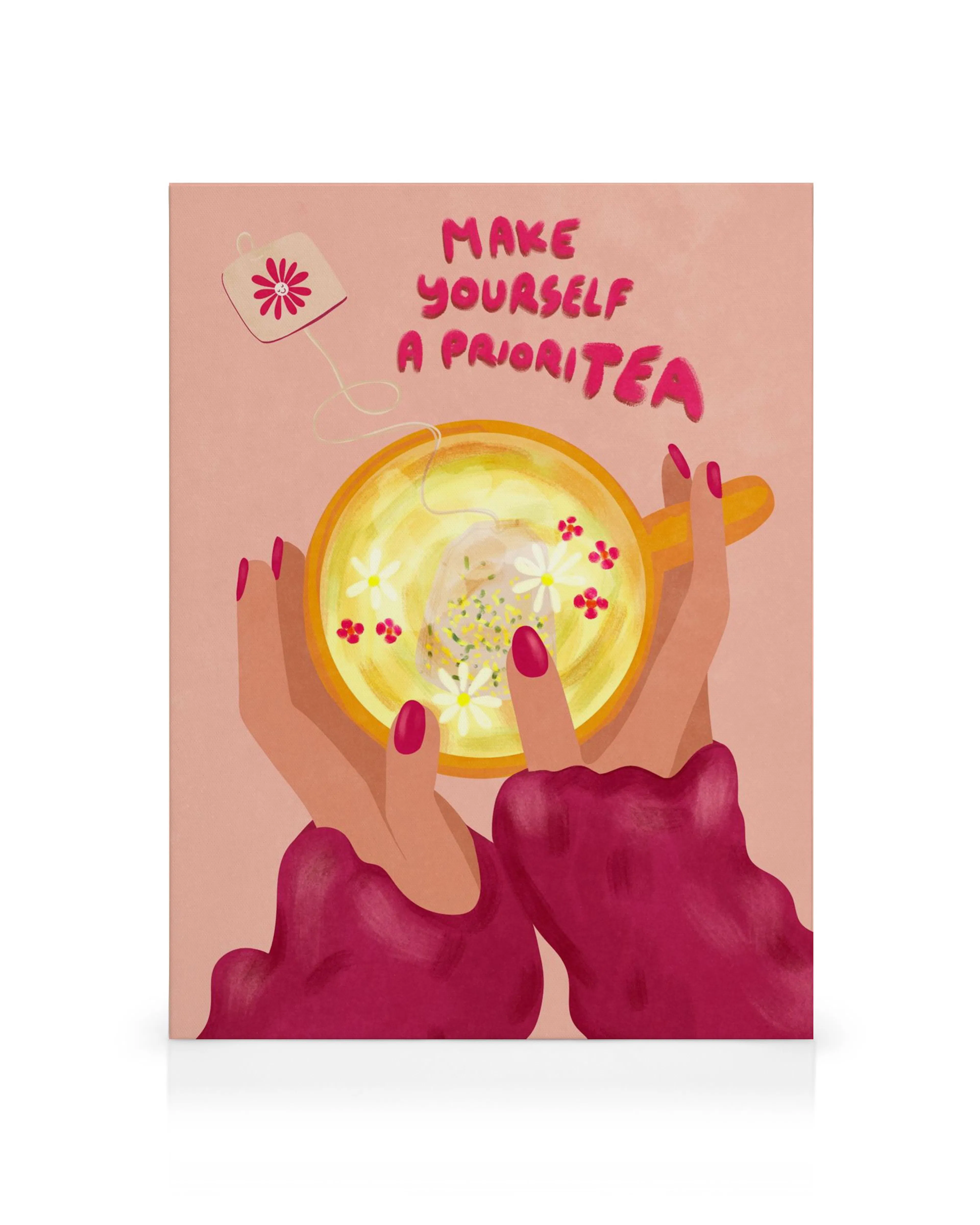 A canvas print featuring hands holding a cup of tea with flowers and the text Make yourself a prioriTEA.