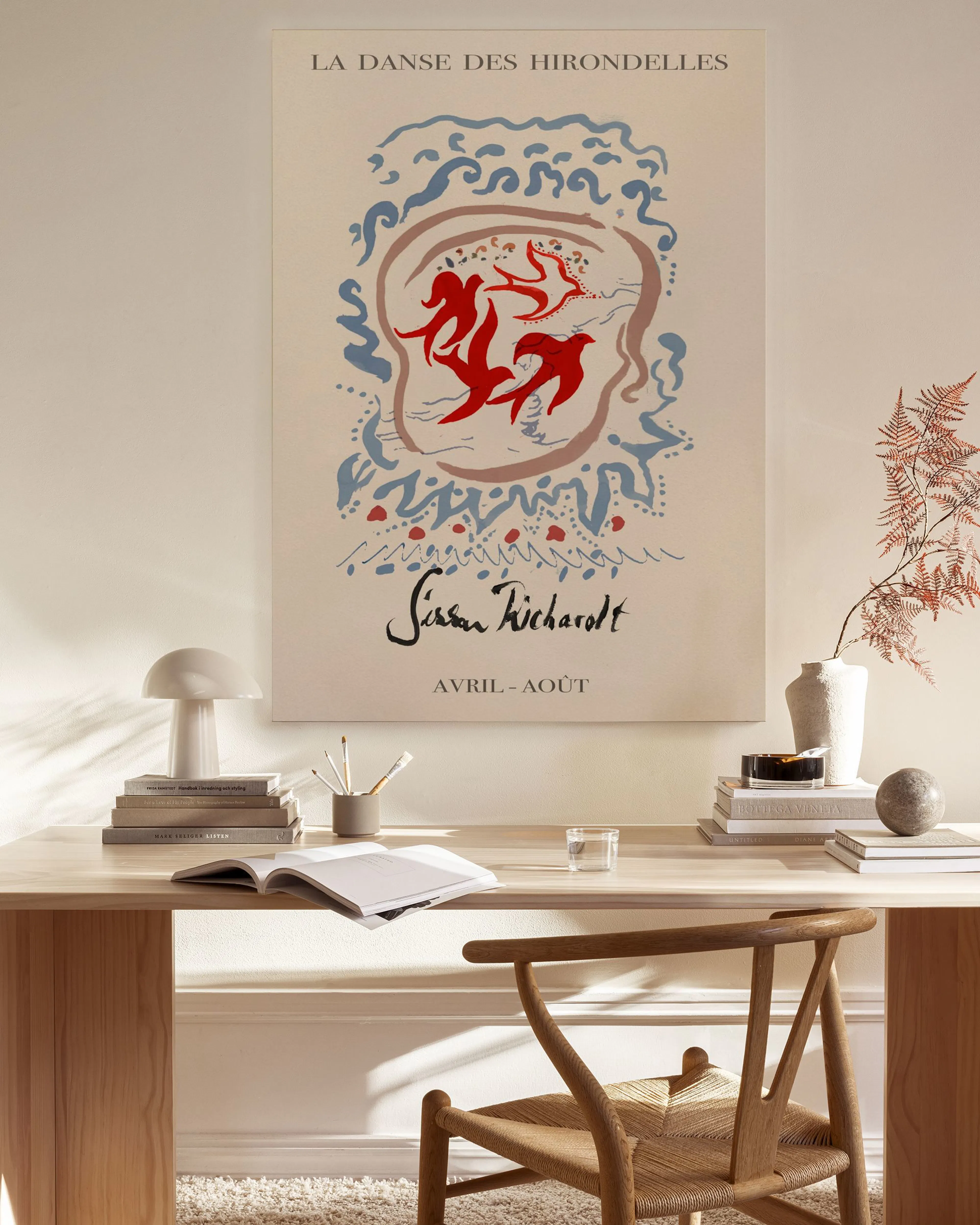 Lienzo con diseño abstracto en rojo y azul, con texto La Danse des Hirondelles, colgado en salón moderno sobre un mueble.