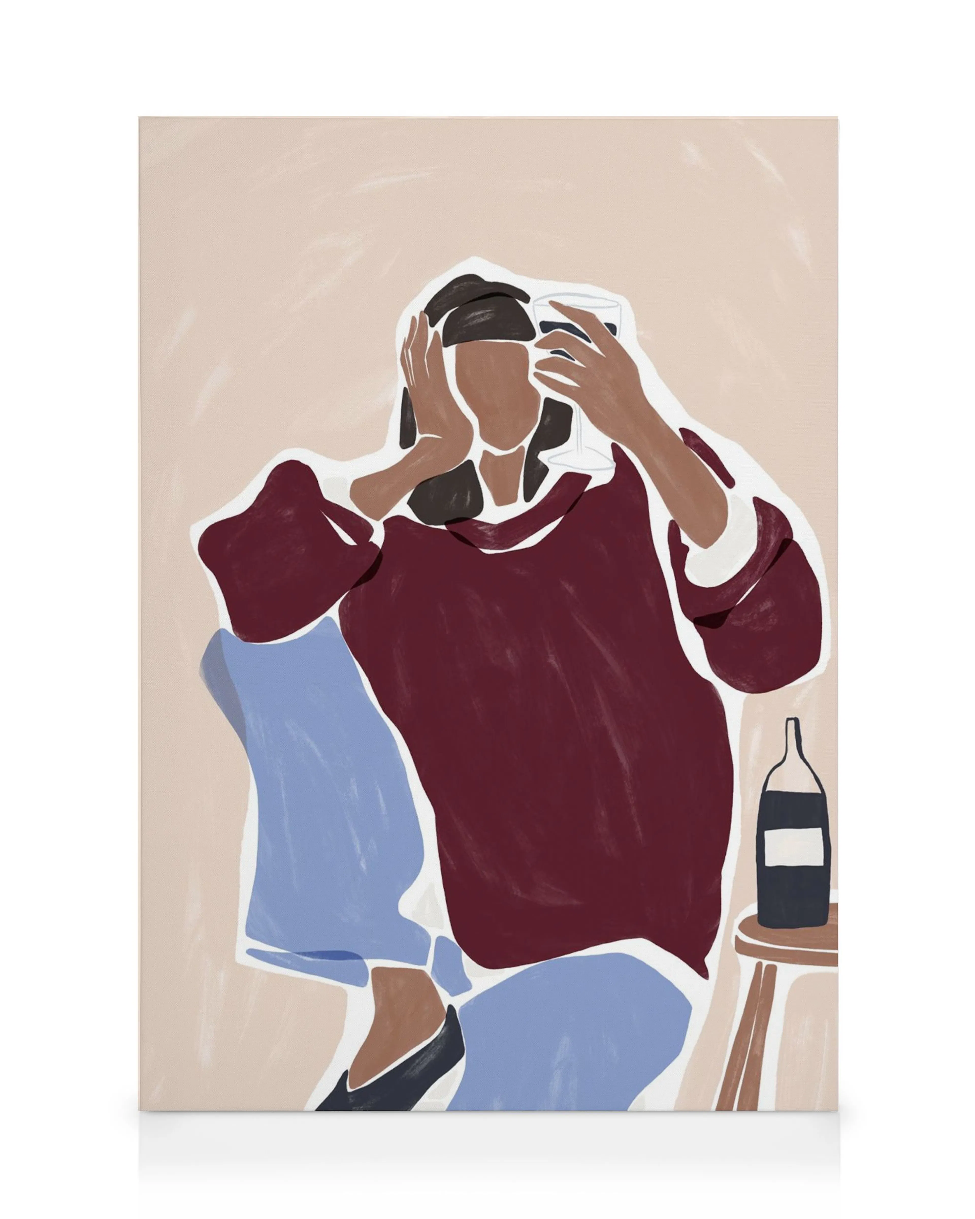 A canvas print portraying a person in a maroon top and blue pants holding a wine glass, with a bottle nearby.
