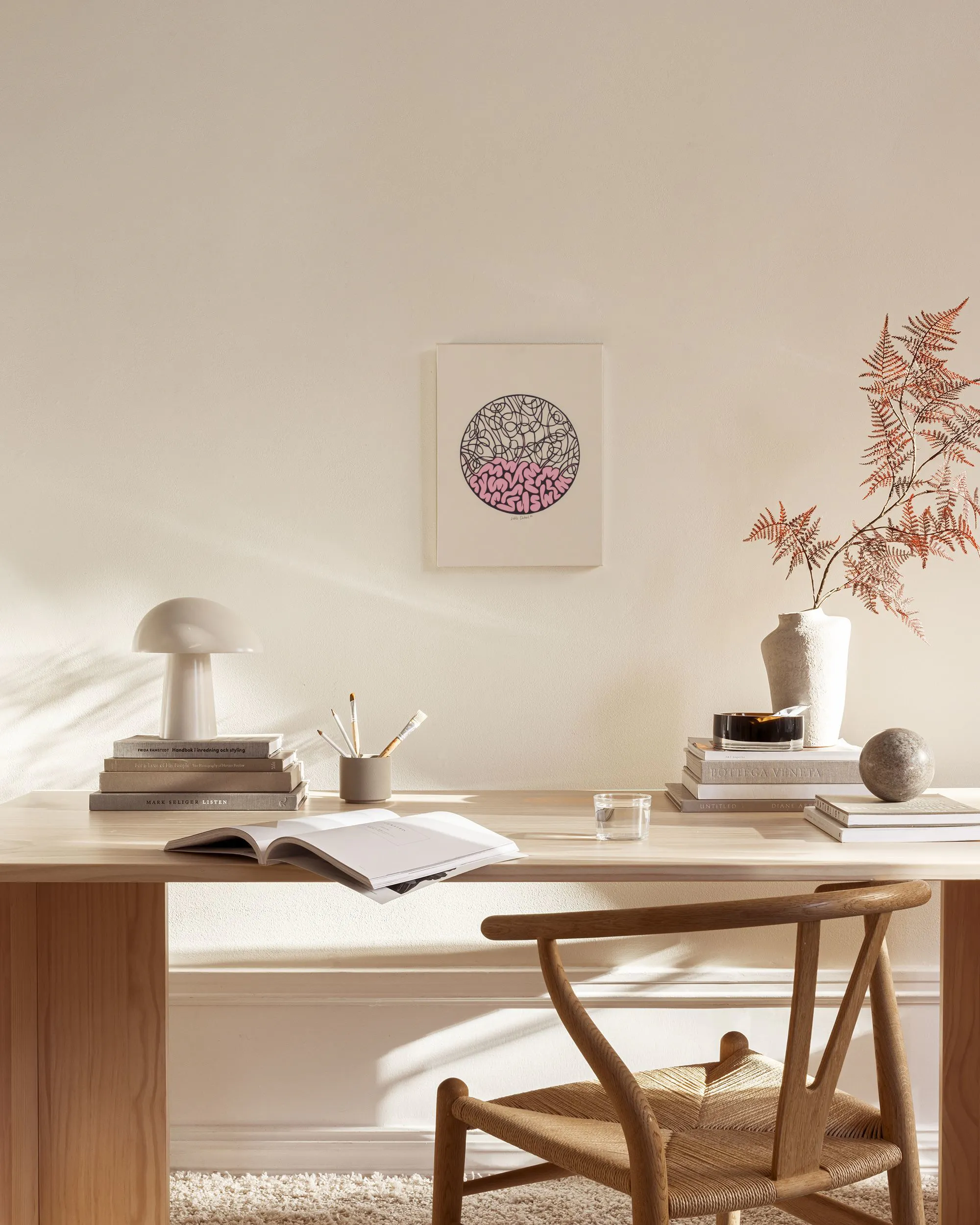 Canvas met roze en zwarte kronkelige lijnen in een cirkel, hangend in een neutrale woonkamer.