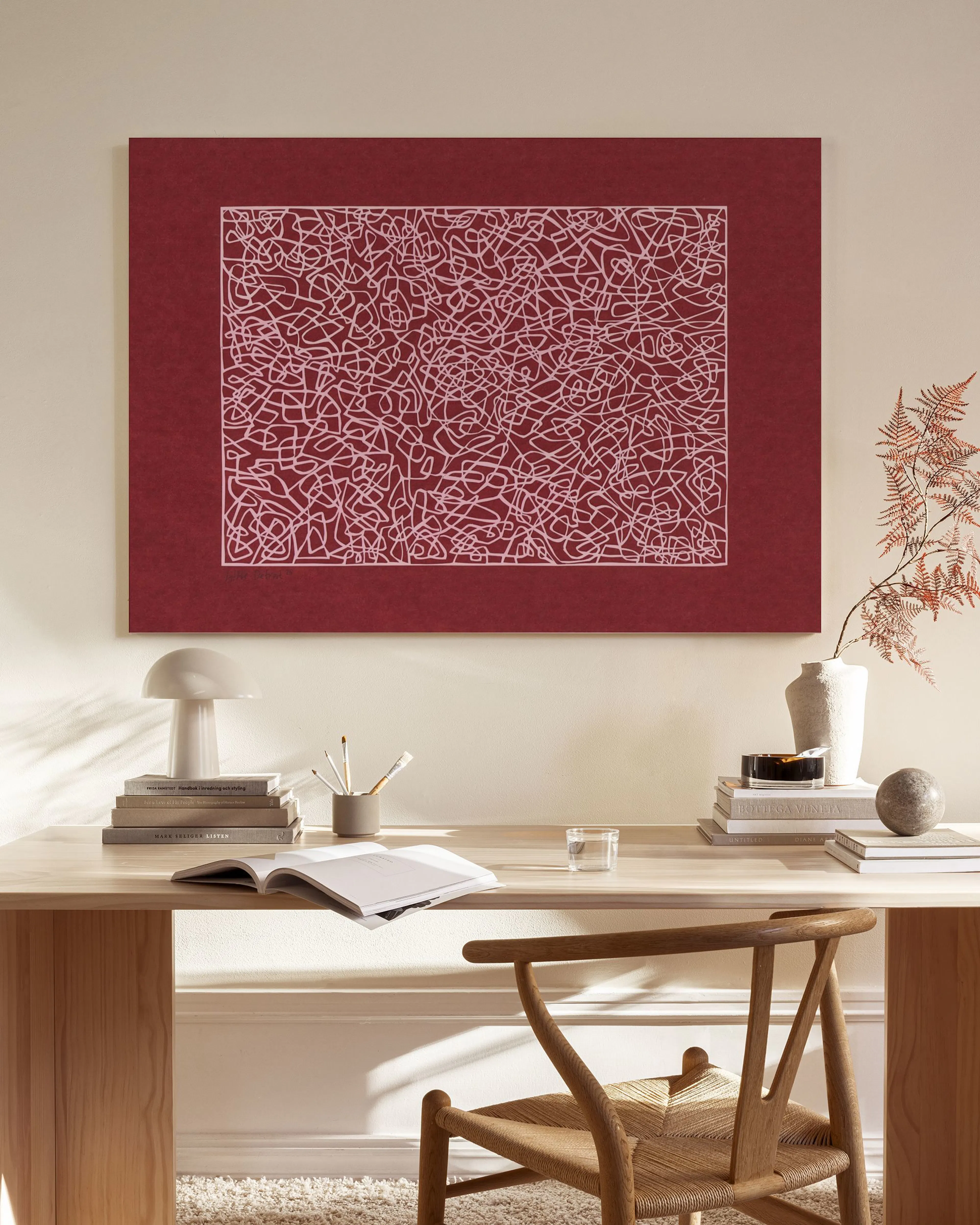 Lienzo de arte abstracto con líneas claras irregulares sobre un fondo rojo vibrante, colgado en una sala de estar moderna.