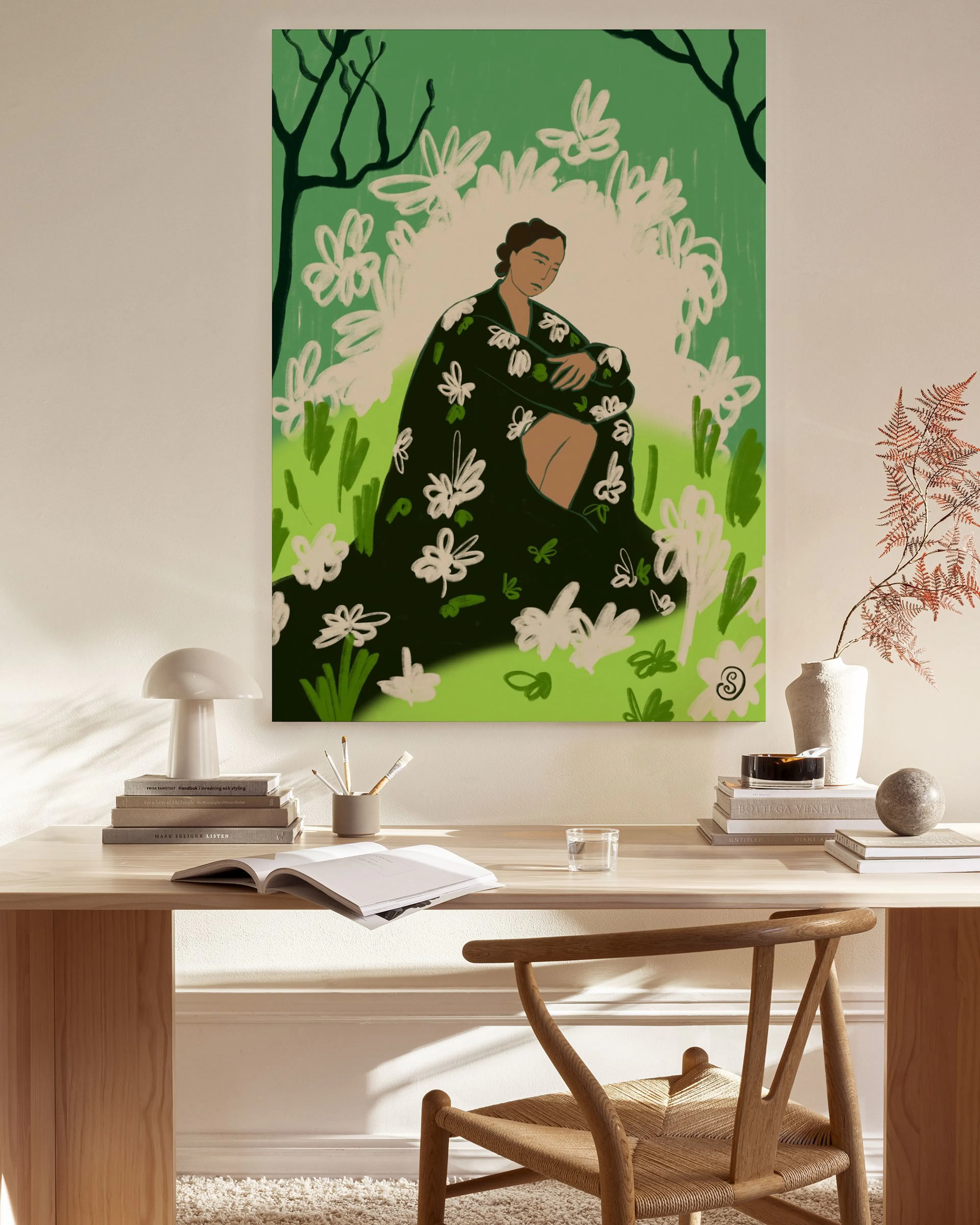 Leinwandbild einer Frau in grüner Kleidung mit weißen Blumen, sitzend in einer grünen Wiese. Hängt in einem modernen Wohnzimmer 