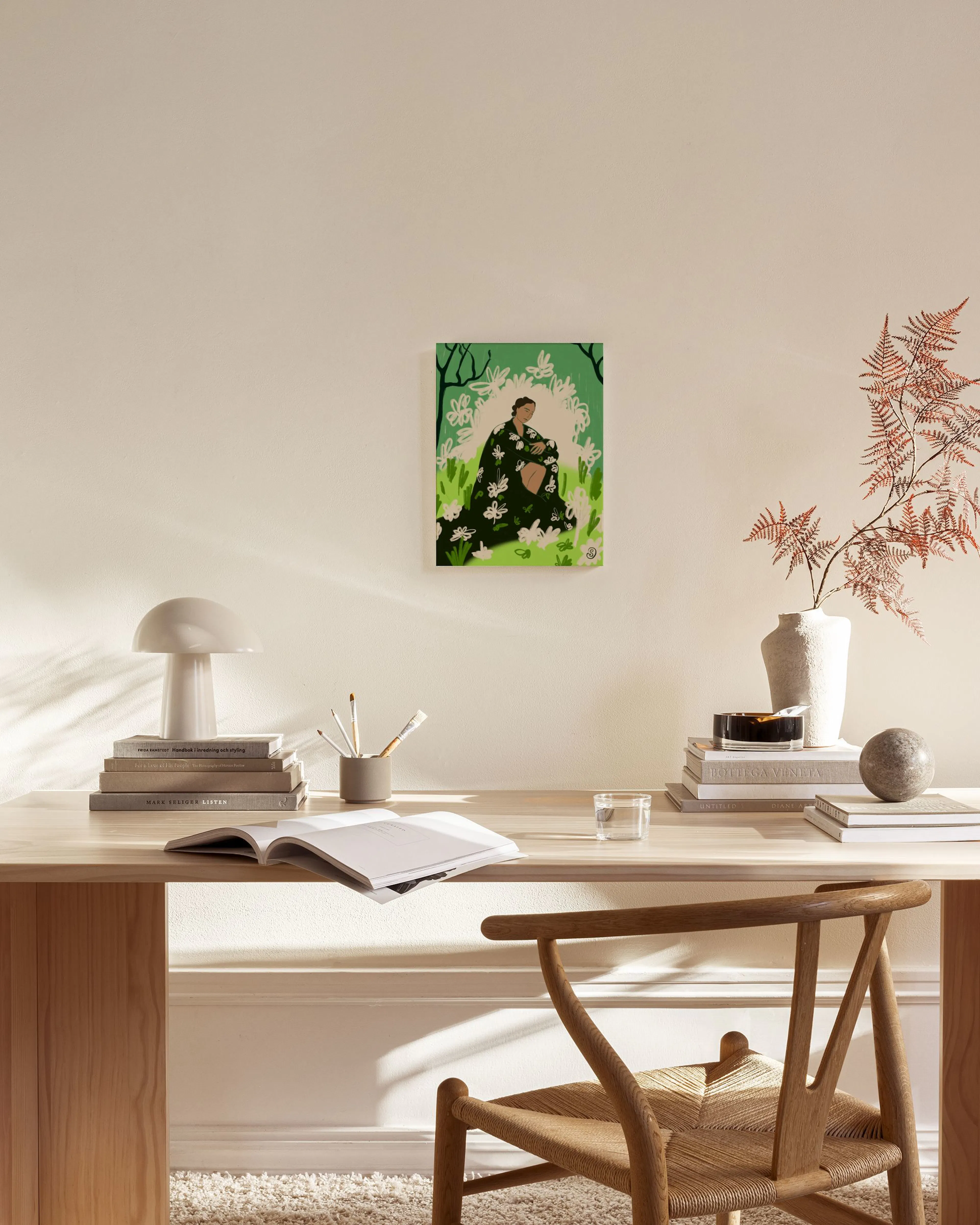 A woman in a floral dress amidst green foliage and white flowers, hanging in a bright living room.