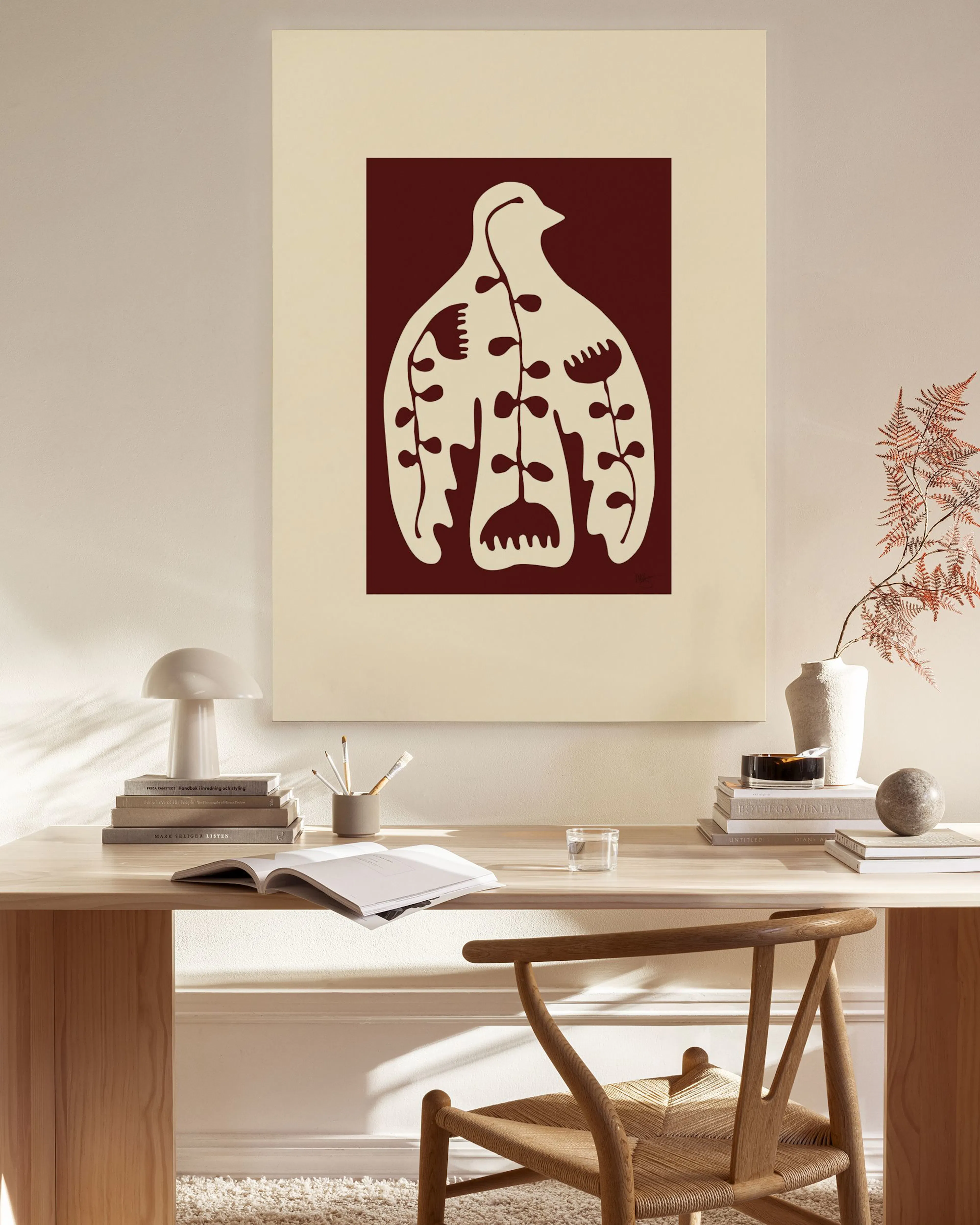 Leinwandbild mit weißer, stilisierter Vogelform und floralen Elementen auf rotem Hintergrund, über einem Sideboard im Wohnzimmer