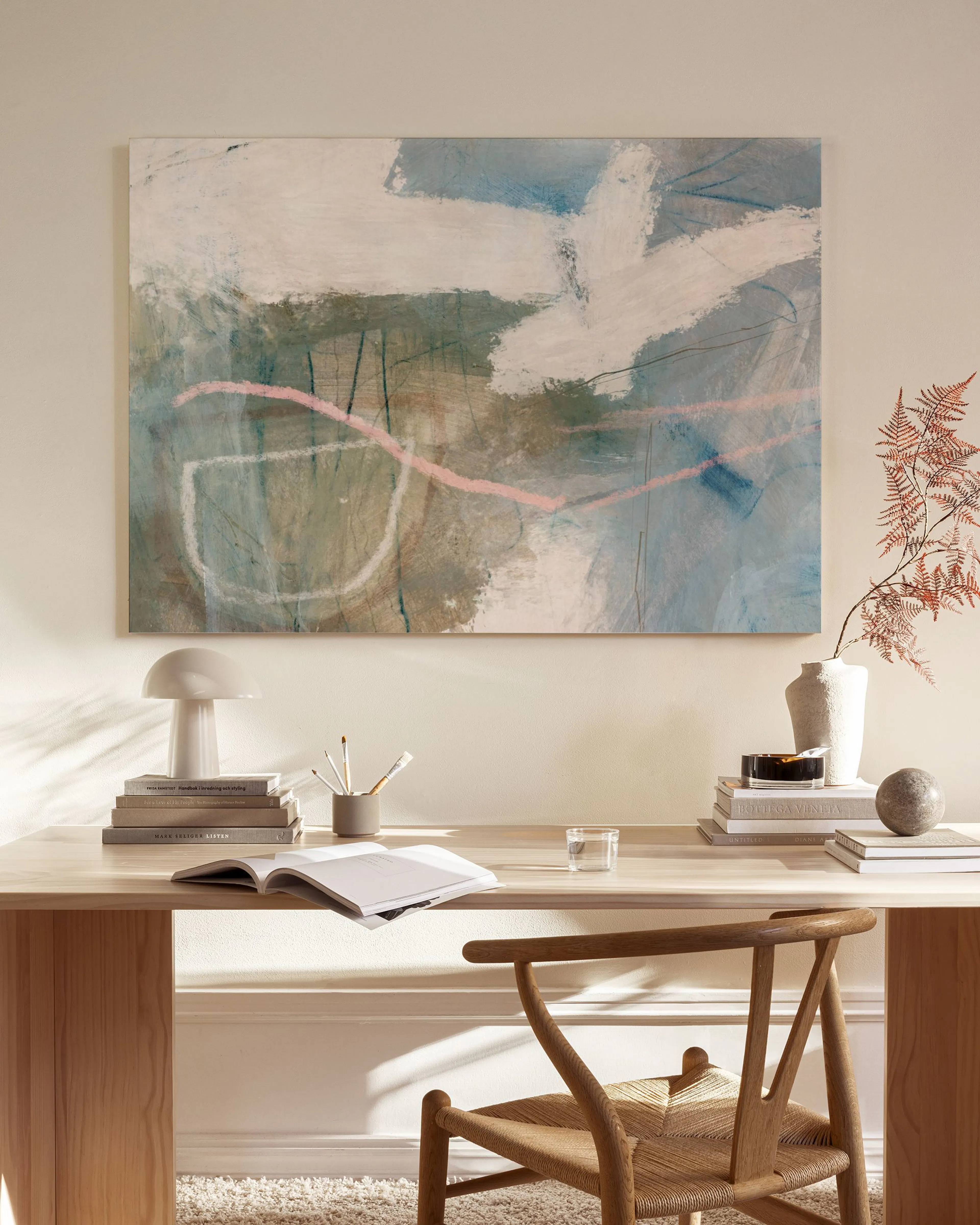 Abstract canvas print with broad strokes of white, beige, light blue, and green, accented by thin pink and black lines, displaye