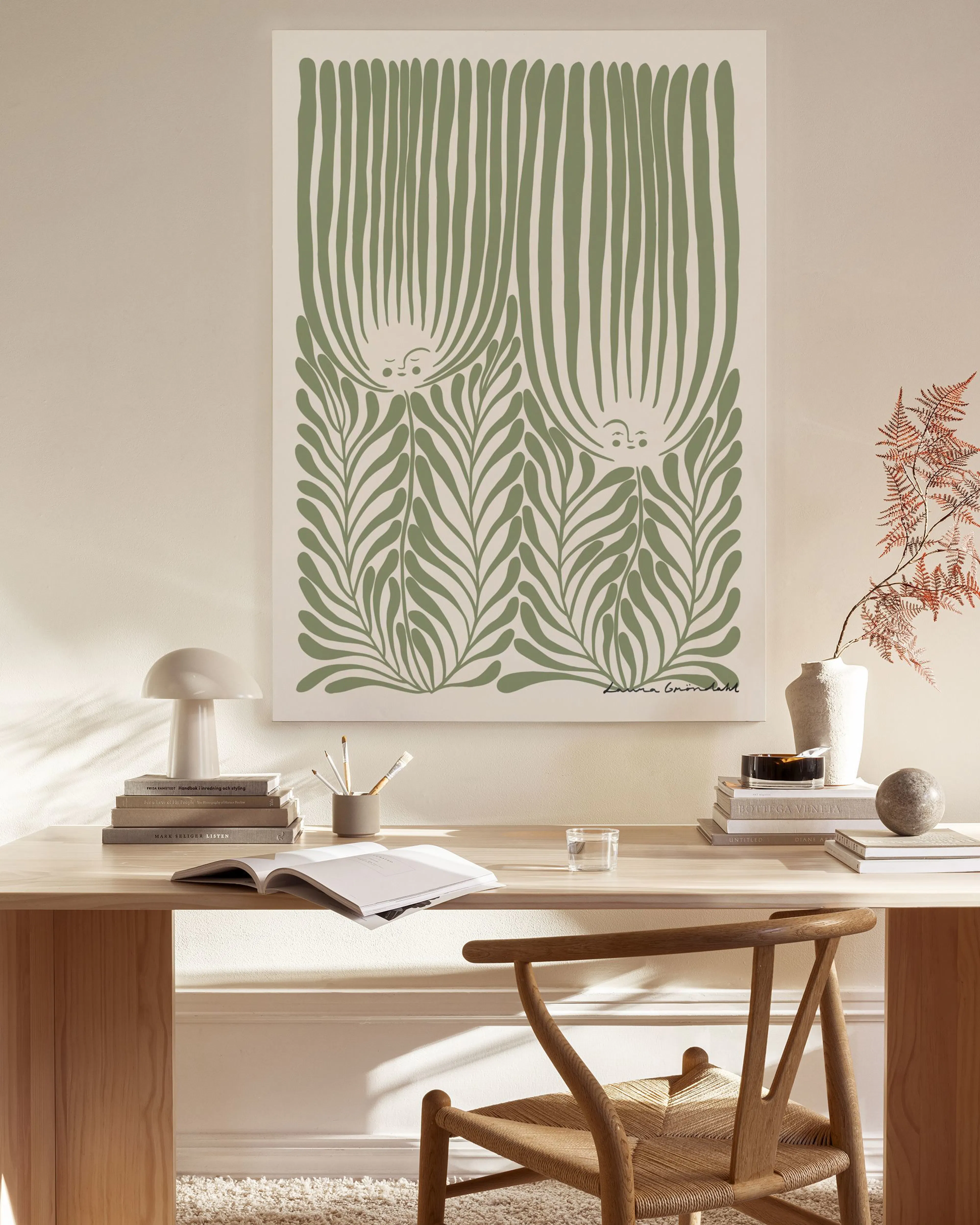 Leinwandbild mit stilisierten grünen Pflanzenmotiven, hängend über einem Sideboard in einem beigen Wohnzimmer.