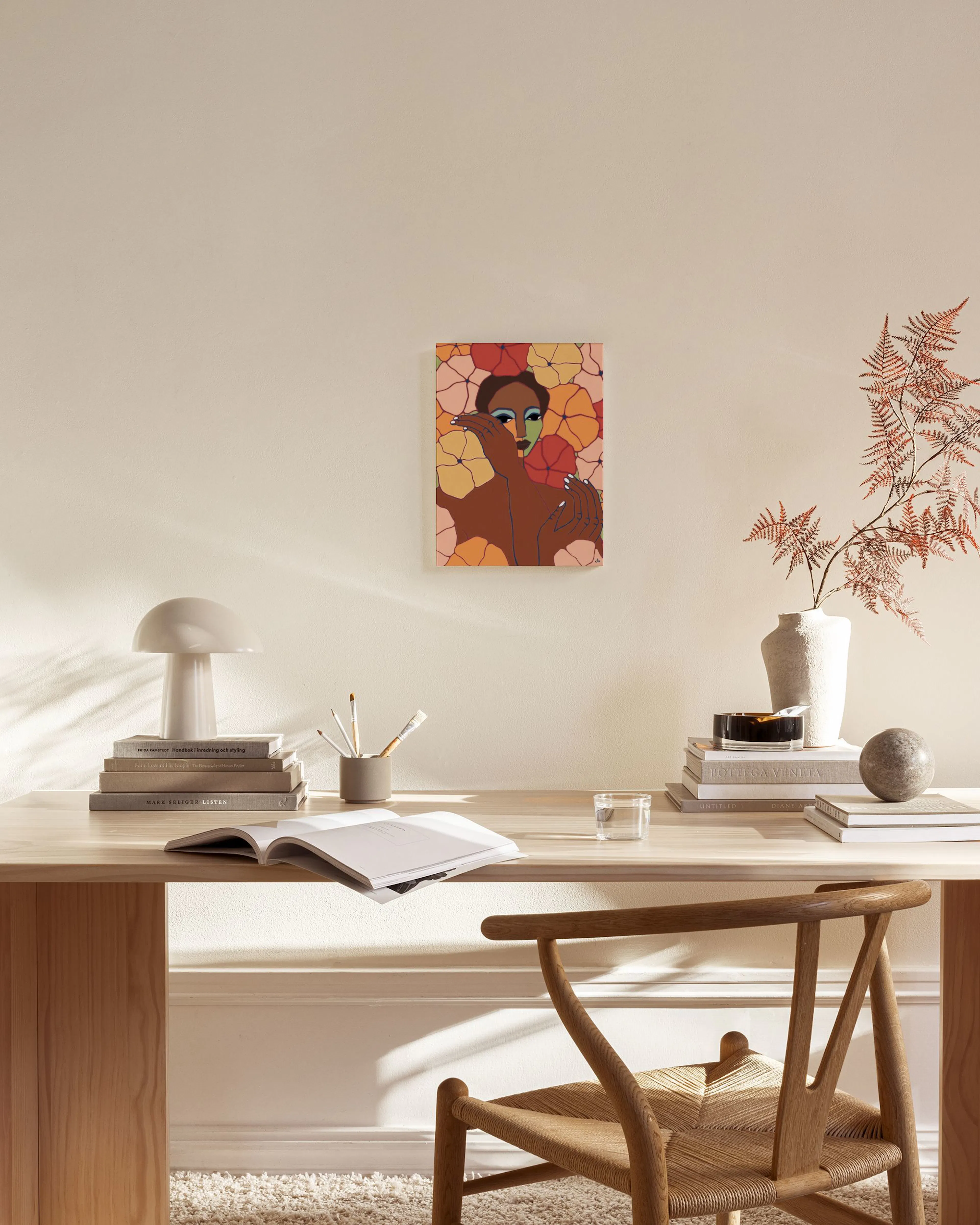 Leinwandbild einer Frau mit bunten Blüten auf einer hellen Wand über einem Sideboard im Wohnzimmer.