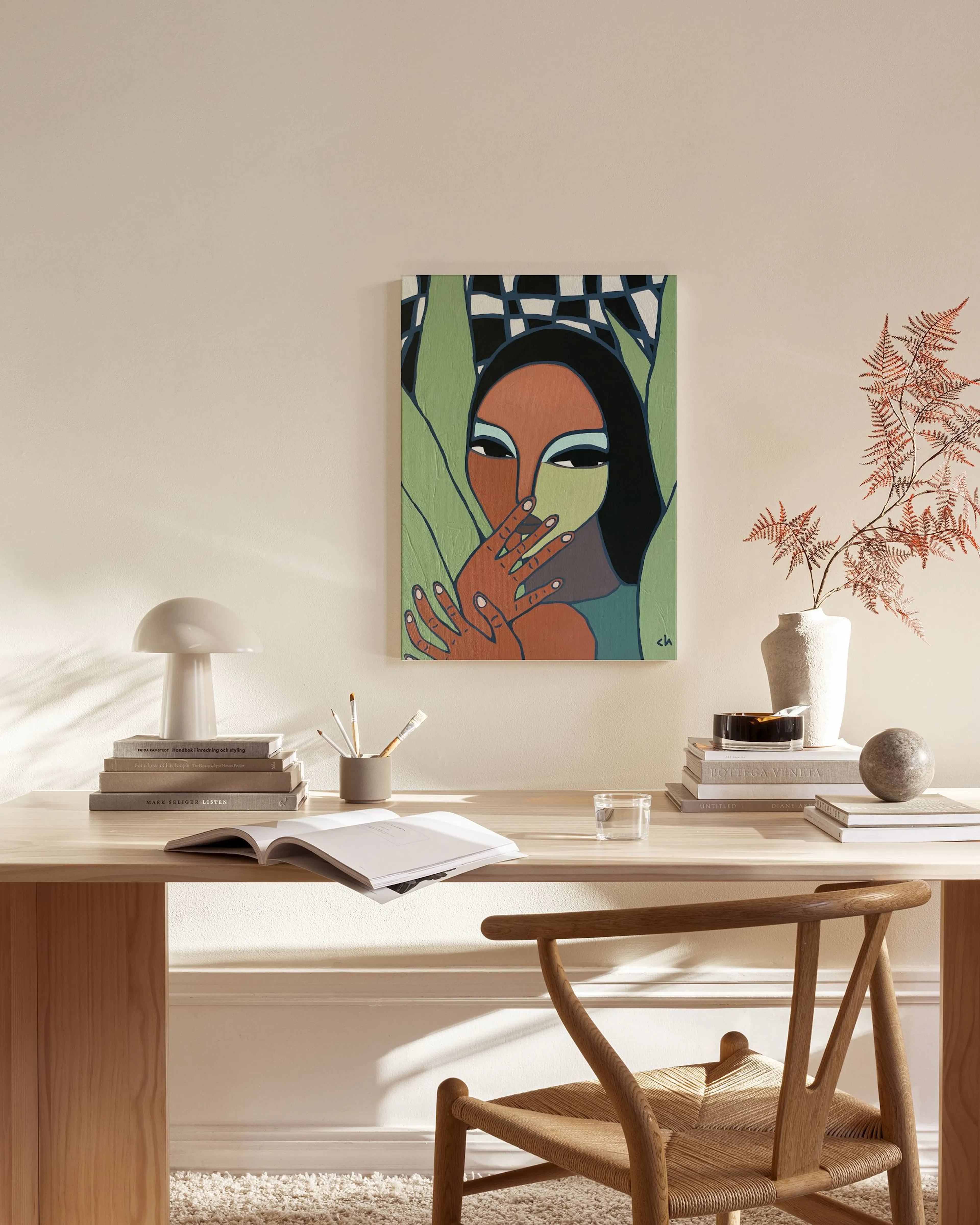 A colorful art print of a woman covering her mouth, with green leaves and a checkered pattern, displayed in a light-toned living