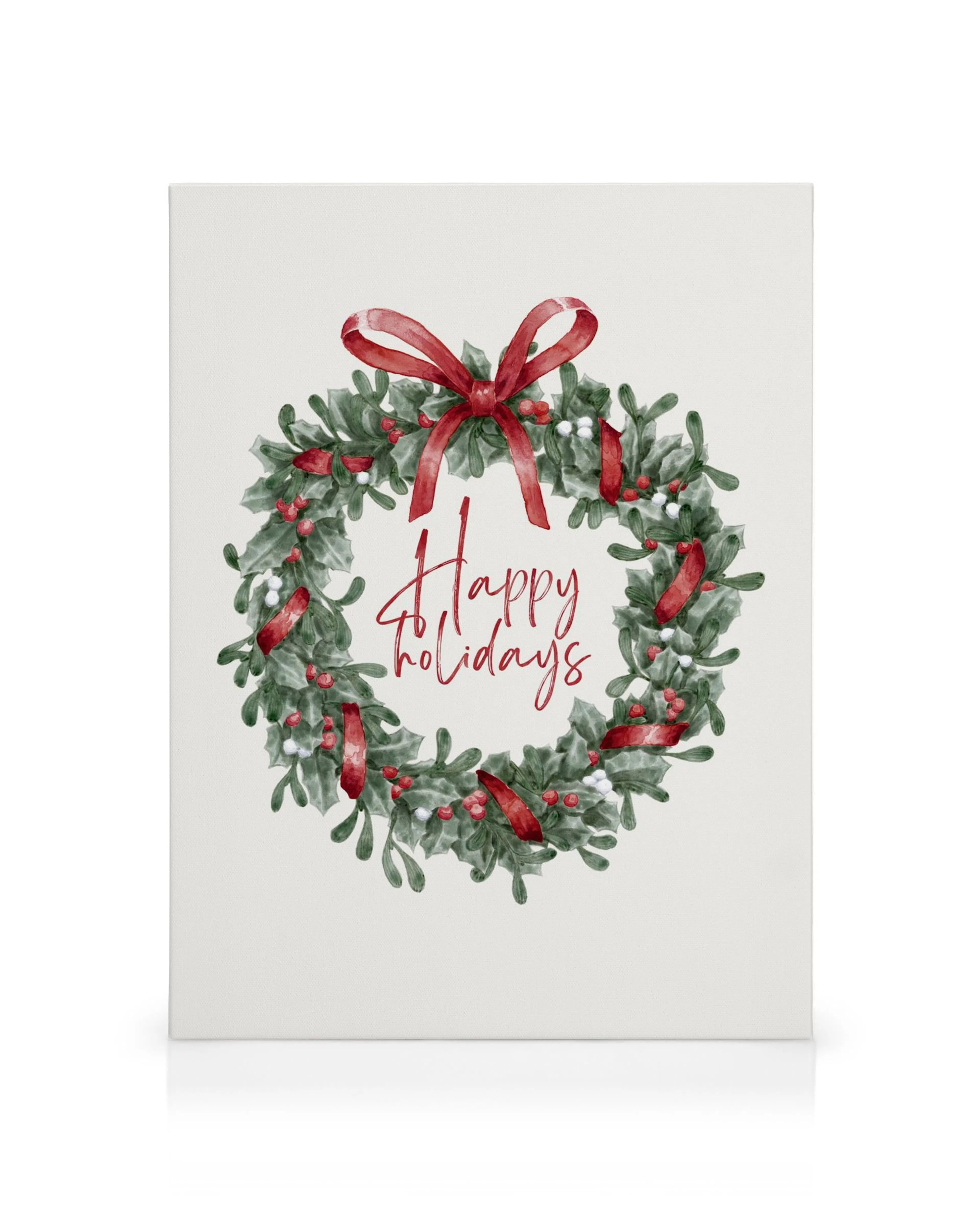 Vánoční věnec z cesmínových listů, červených bobulí a bílých kuliček se stuhou, uprostřed nápis Happy holidays.