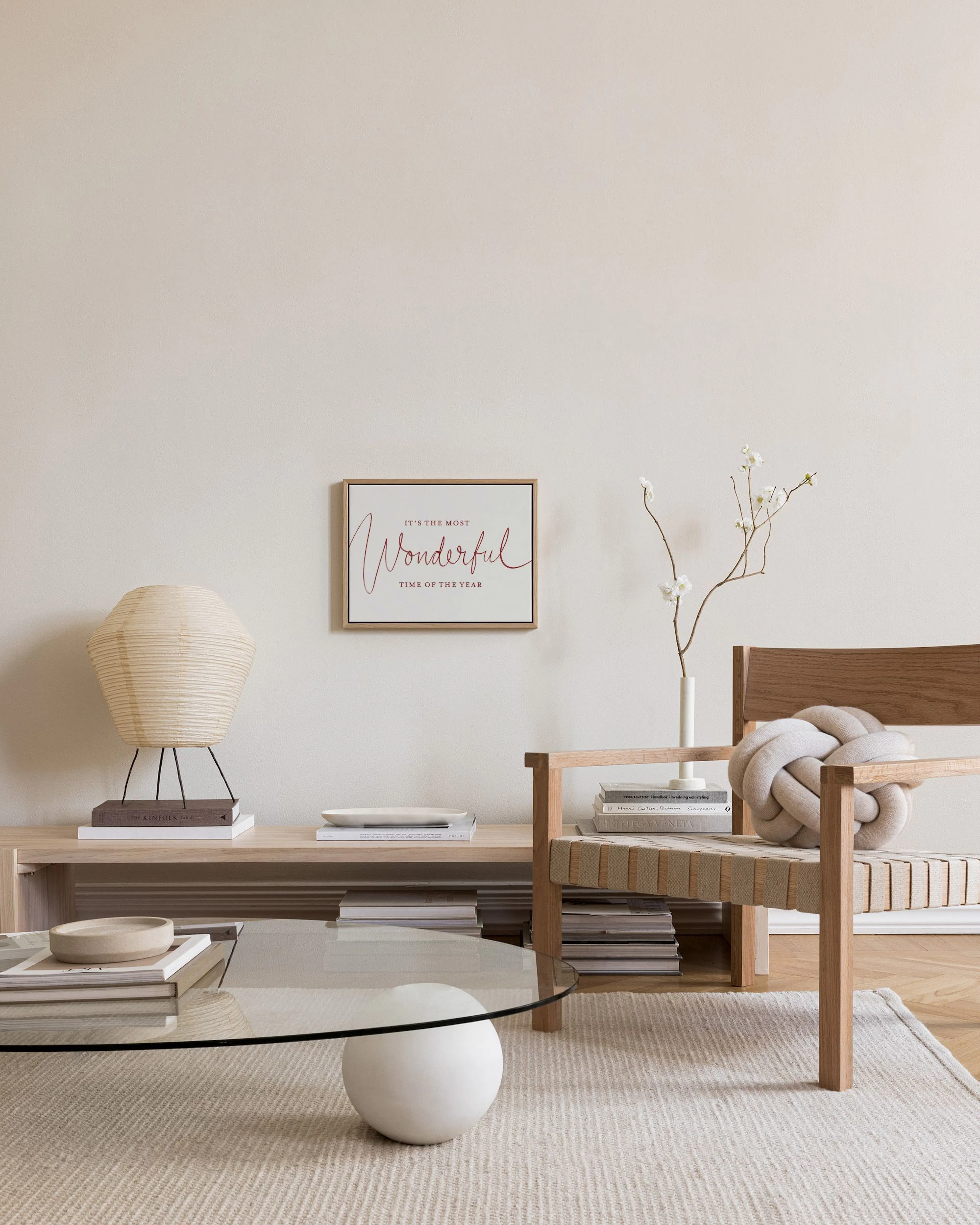 Canvas met rode tekst Its the Most Wonderful Time of the Year hangend in een neutrale woonkamer.