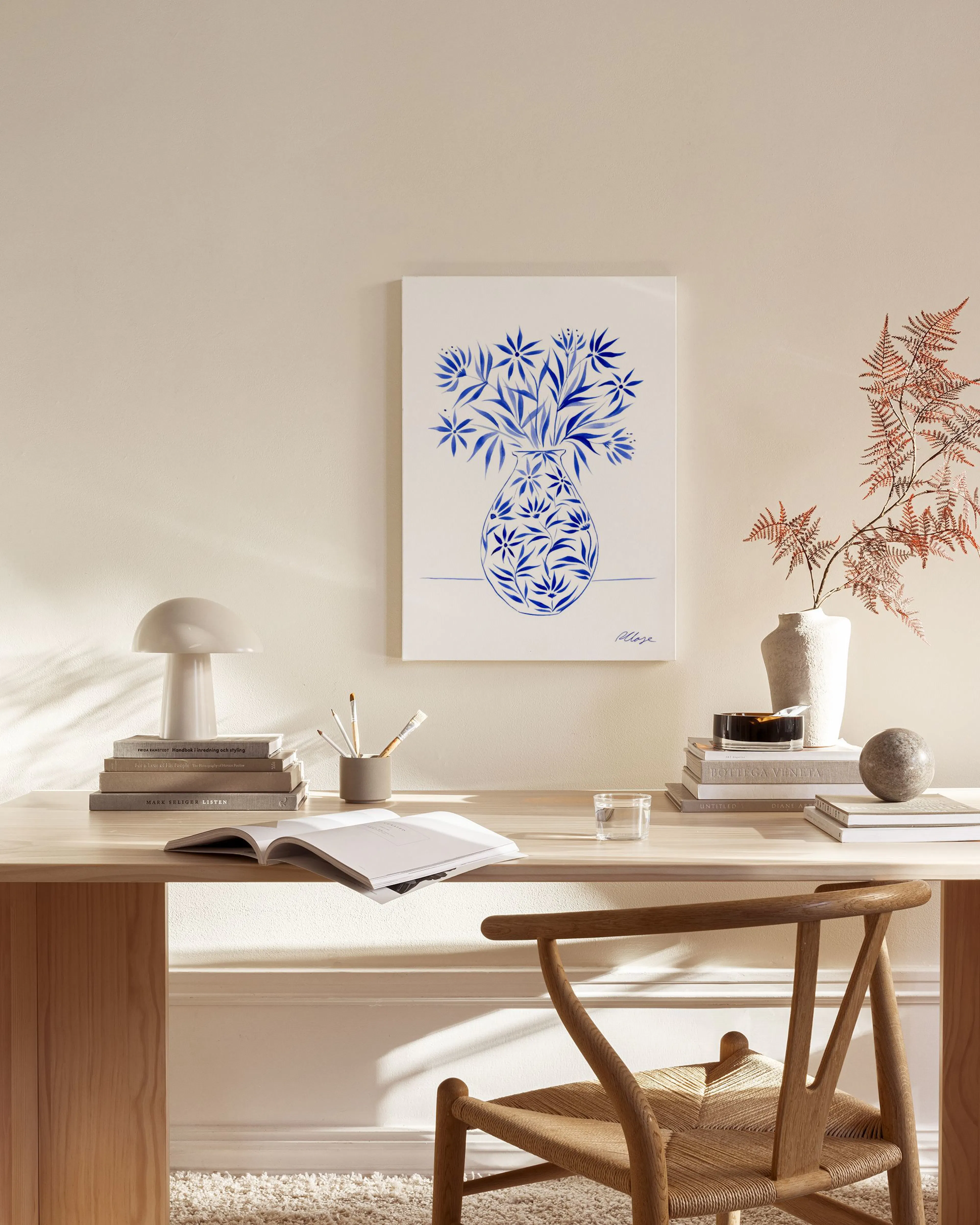 Toile murale, vase bleu et blanc rempli de fleurs bleues, suspendue dans un salon moderne au-dessus dun banc, avec une table bas
