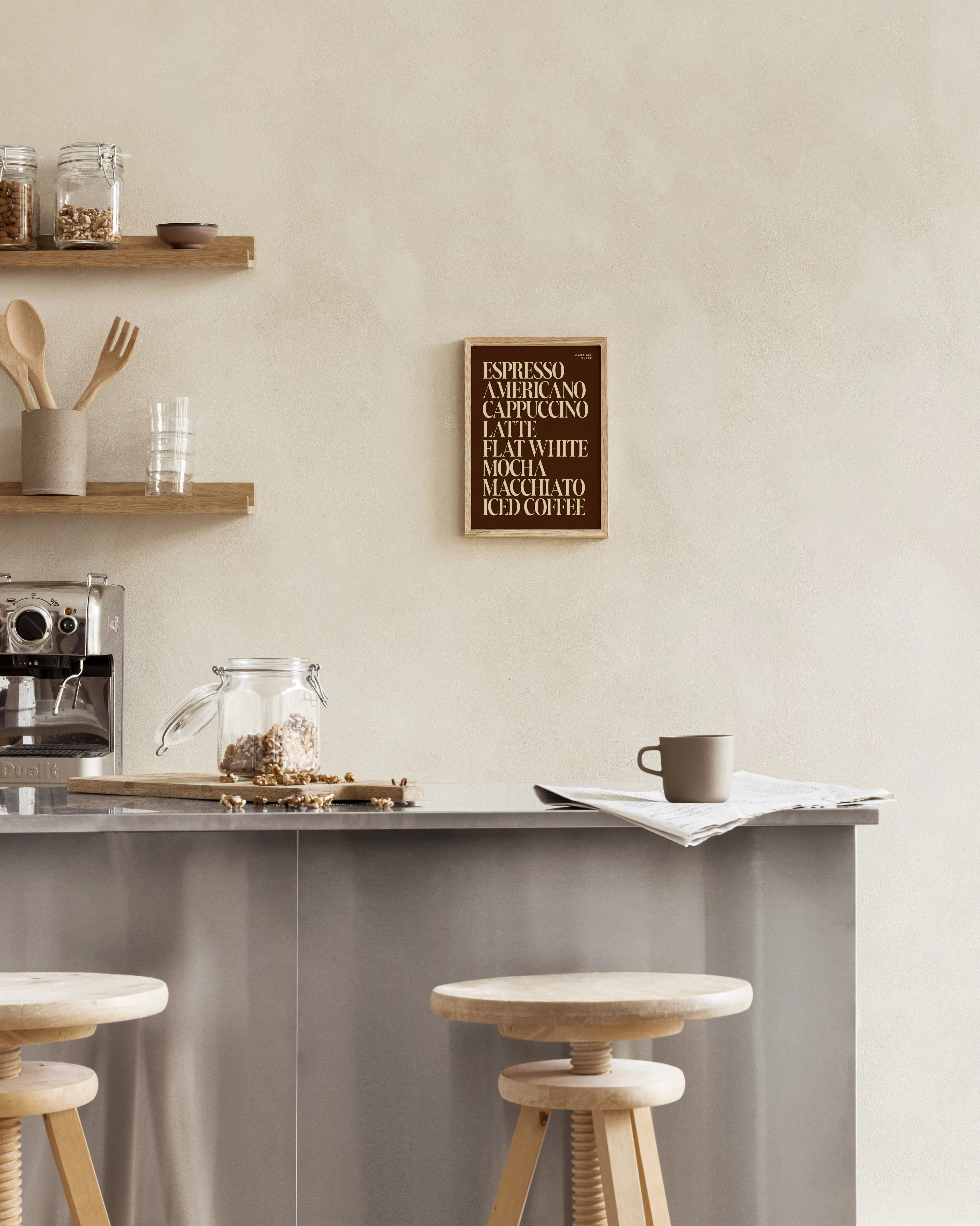 A coffee-themed print with a list of espresso drinks in beige text on a dark brown background, displayed in a modern kitchen.
