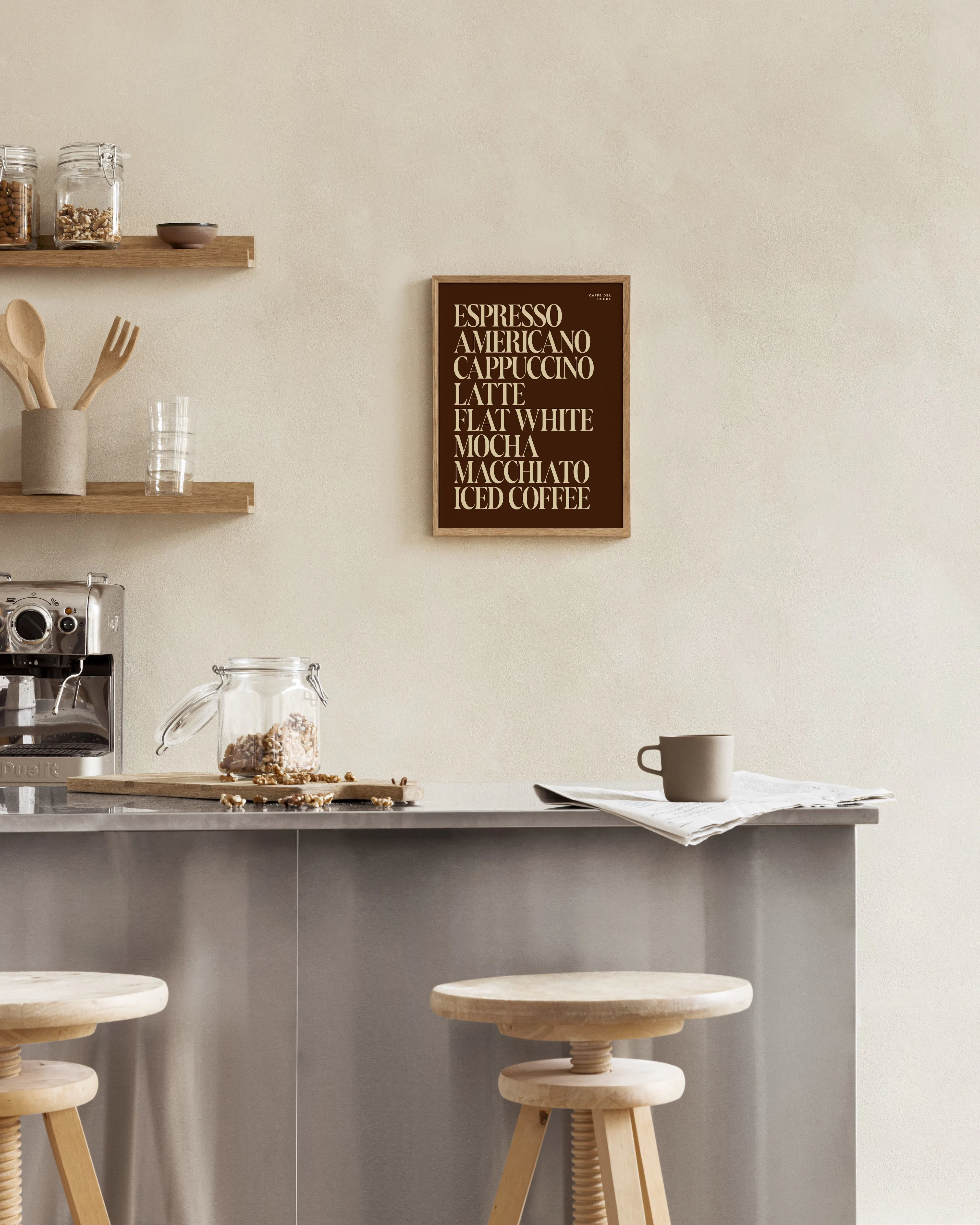 Poster mit Kaffeeliste in Braun und Beige über einer Kücheninsel mit Barhockern.