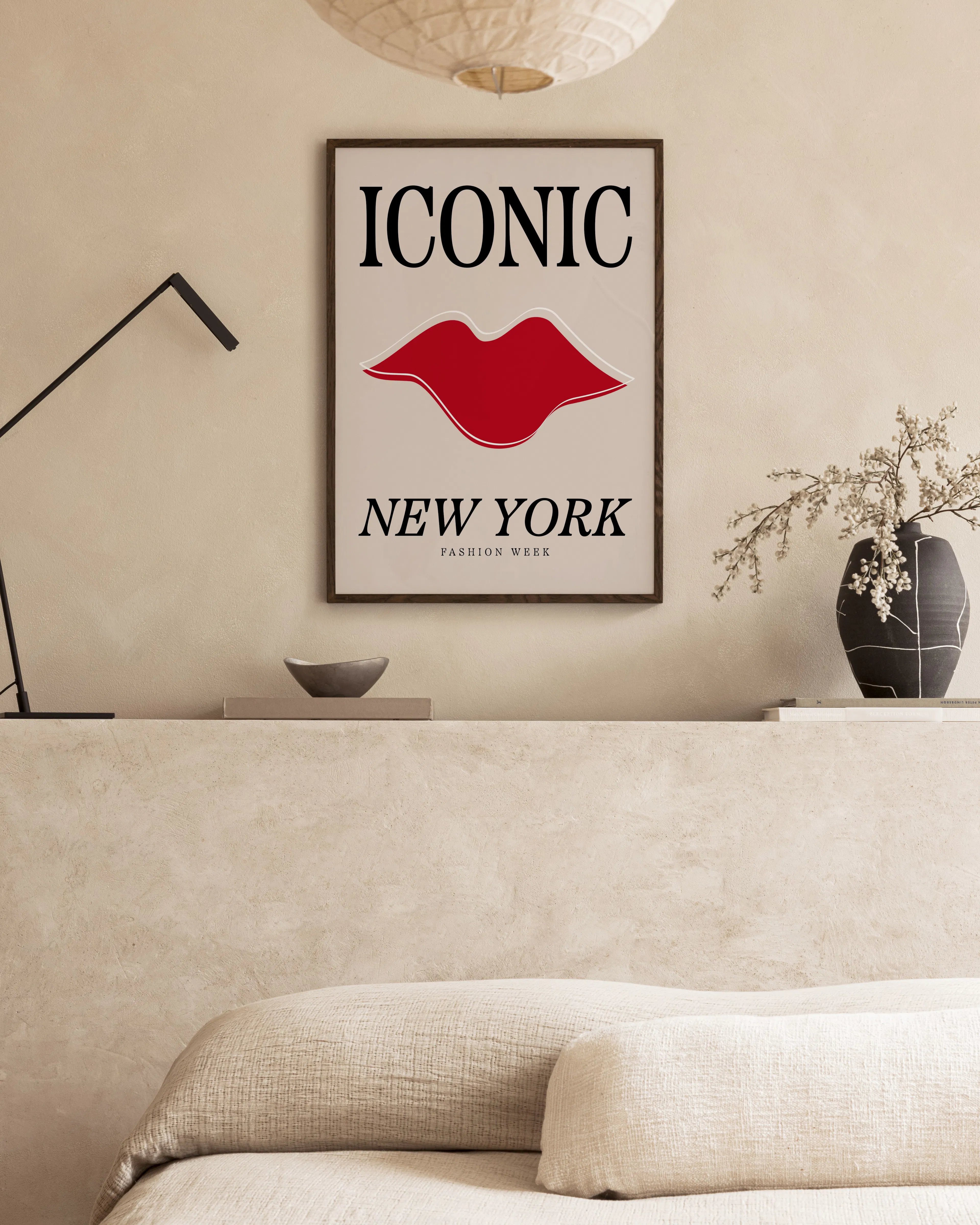 Poster ICONIC NEW YORK FASHION WEEK“ mit roten Lippen, über einem Sofa in einem modern eingerichteten Raum.