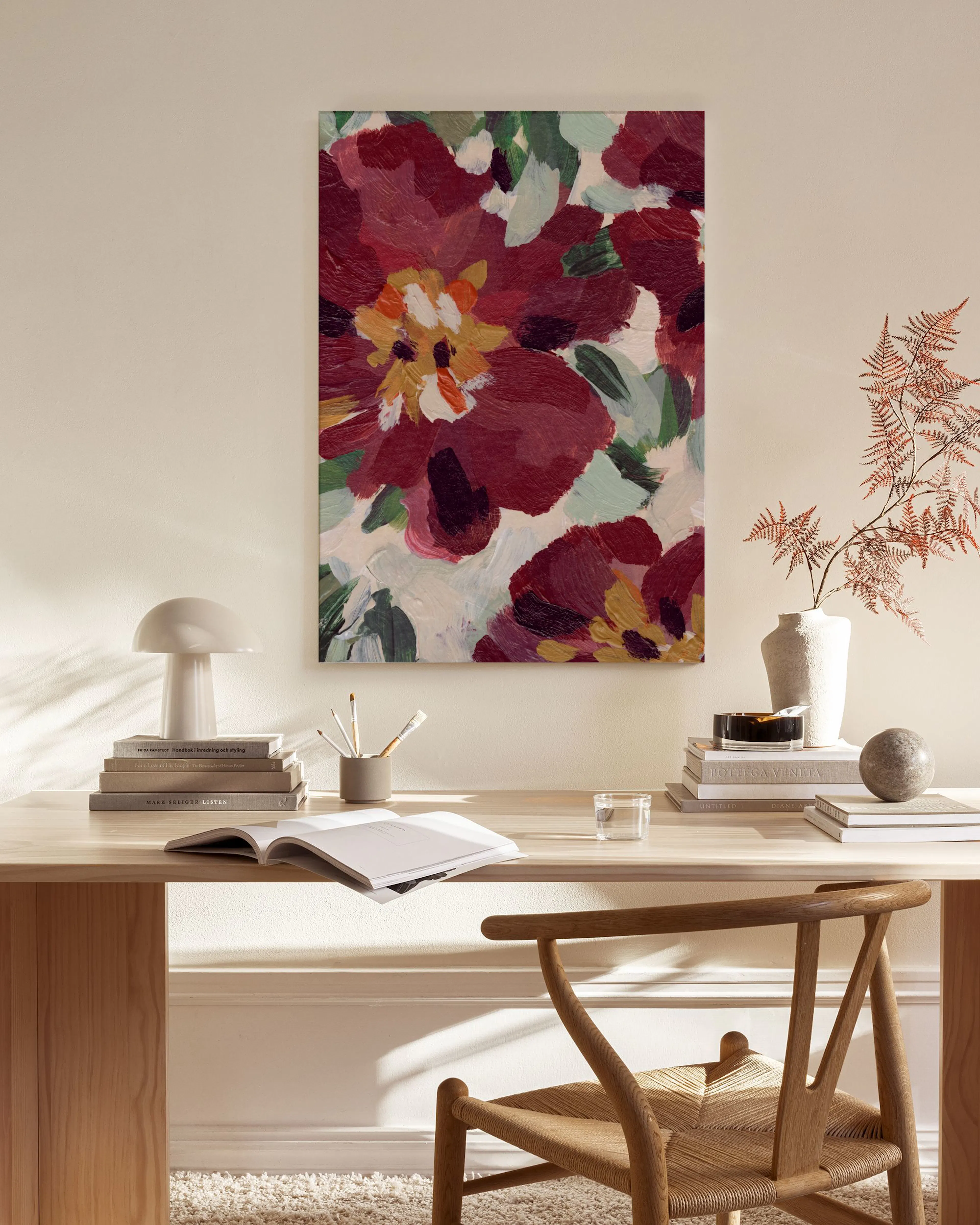 Toile Winter Market Paris aux motifs floraux rouges, accrochée dans un salon lumineux avec un fauteuil en bois clair.