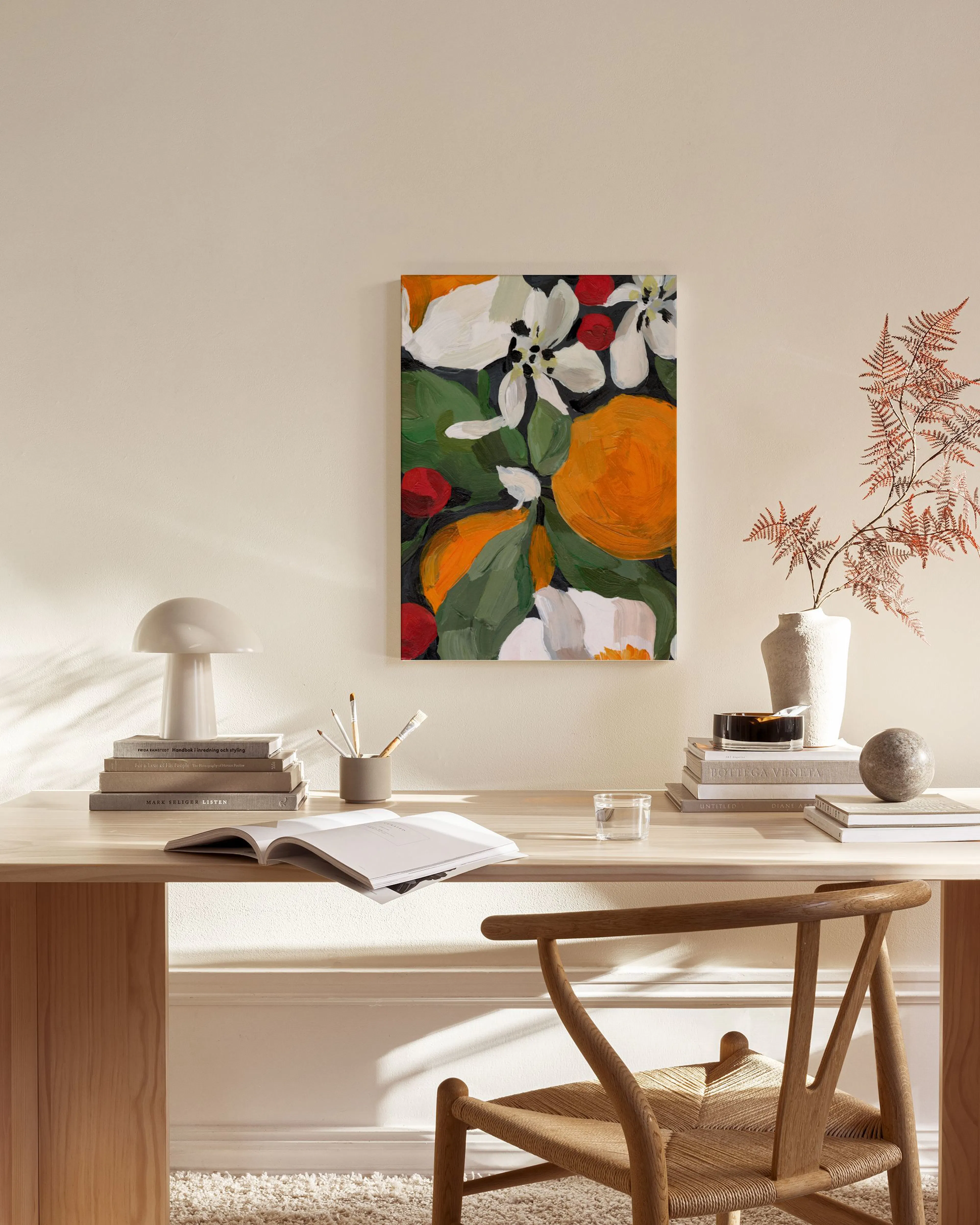 Leinwandbild mit Orangen, weißen Blüten und roten Beeren, hängend im Wohnzimmer über einem Sideboard.